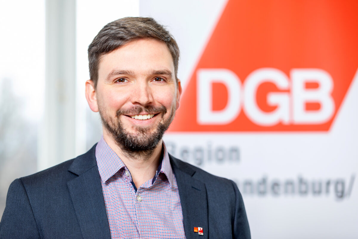 Marcel Molch vor dem Logo des DGB