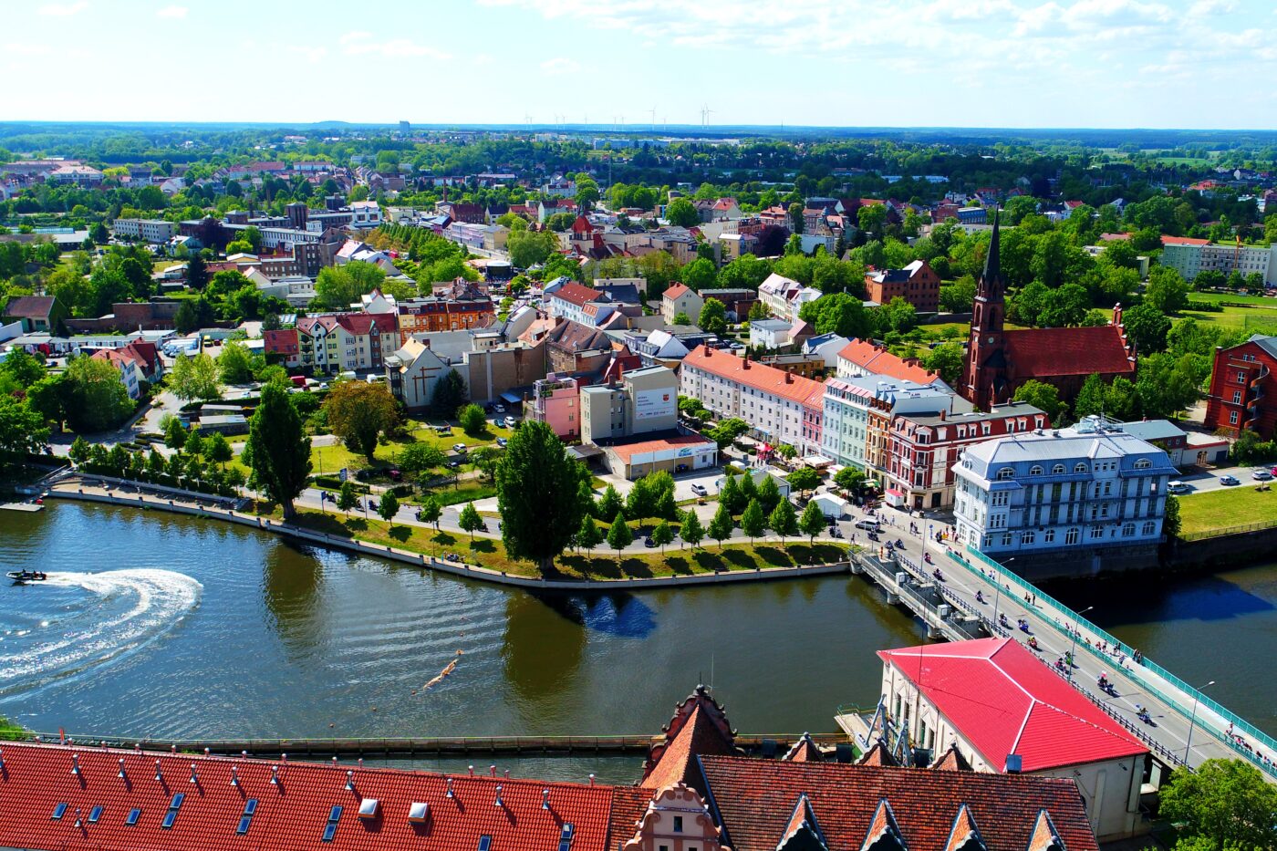 Ein Luftbild von Guben mit Blick auf den Fluss, die Brücke und mehrere Häuser.