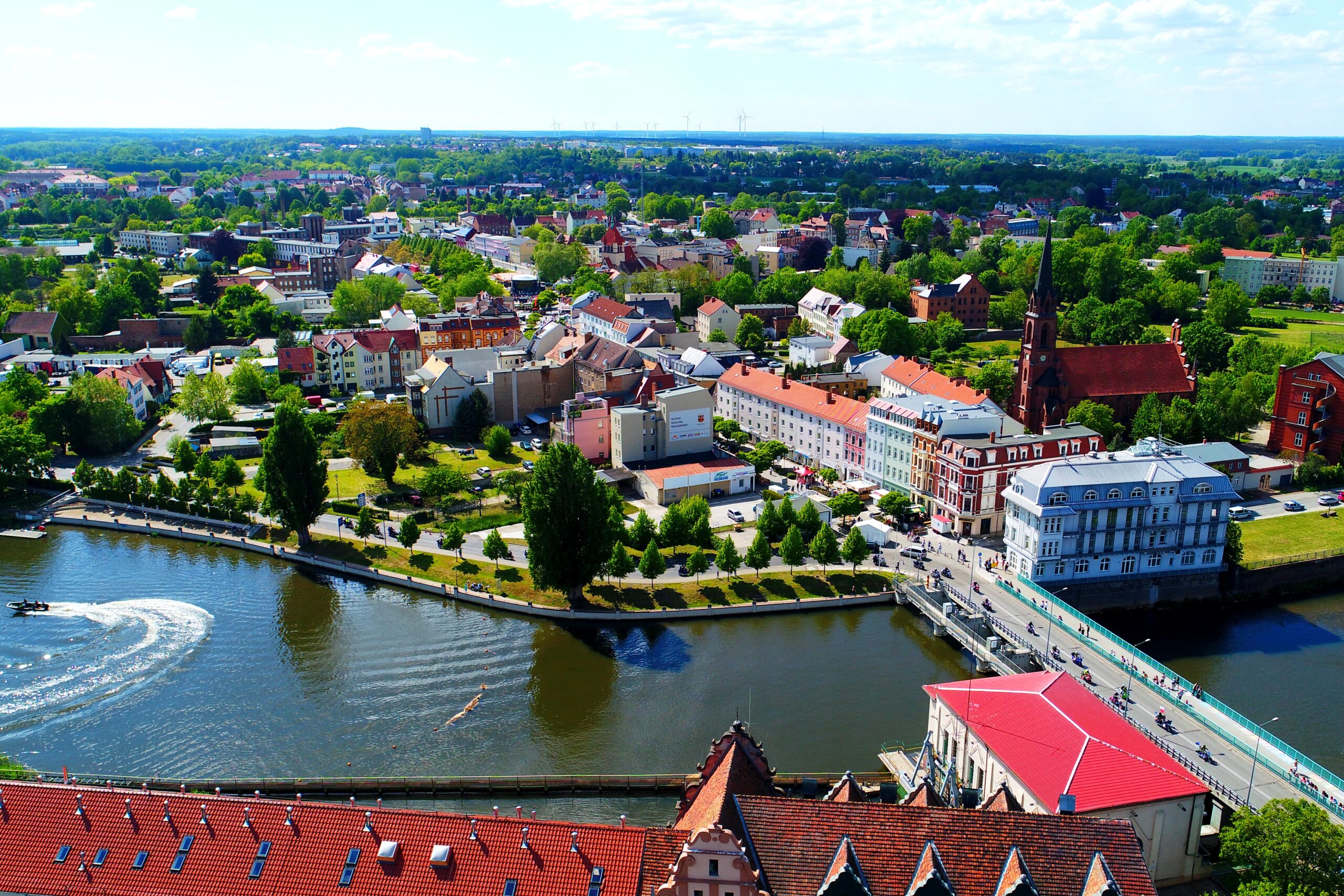 Ein Luftbild von Guben mit Blick auf den Fluss, die Brücke und mehrere Häuser.