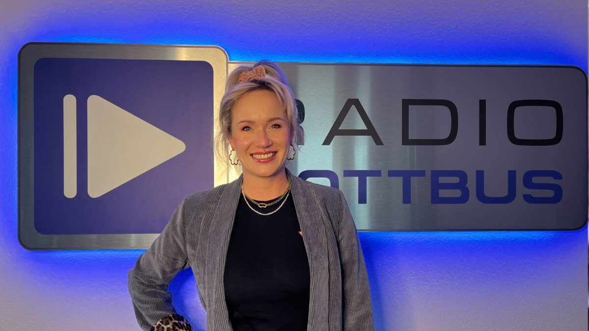 Jessika Dommaschenz von Nagelzauber steht vor dem Radio Cottbus Schild im Medienhaus
