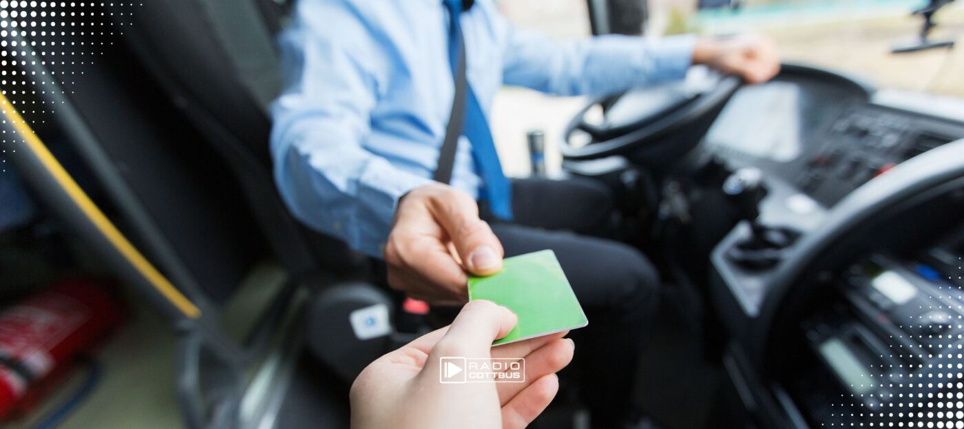 Ein grünes Ticket wird im Bus an den Fahrer übergeben.