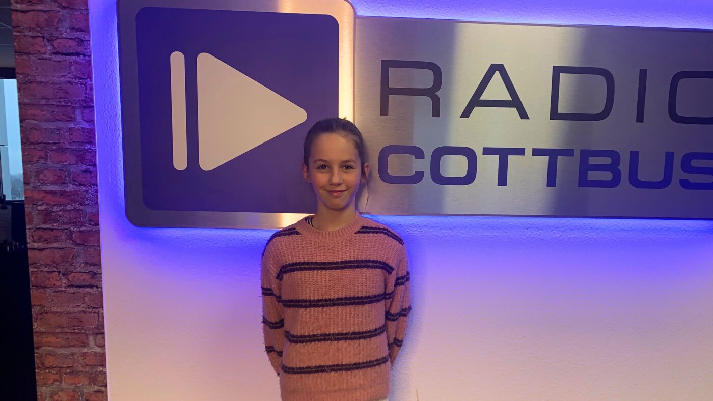 Marie Rubik vor dem Radio Cottbus Logo