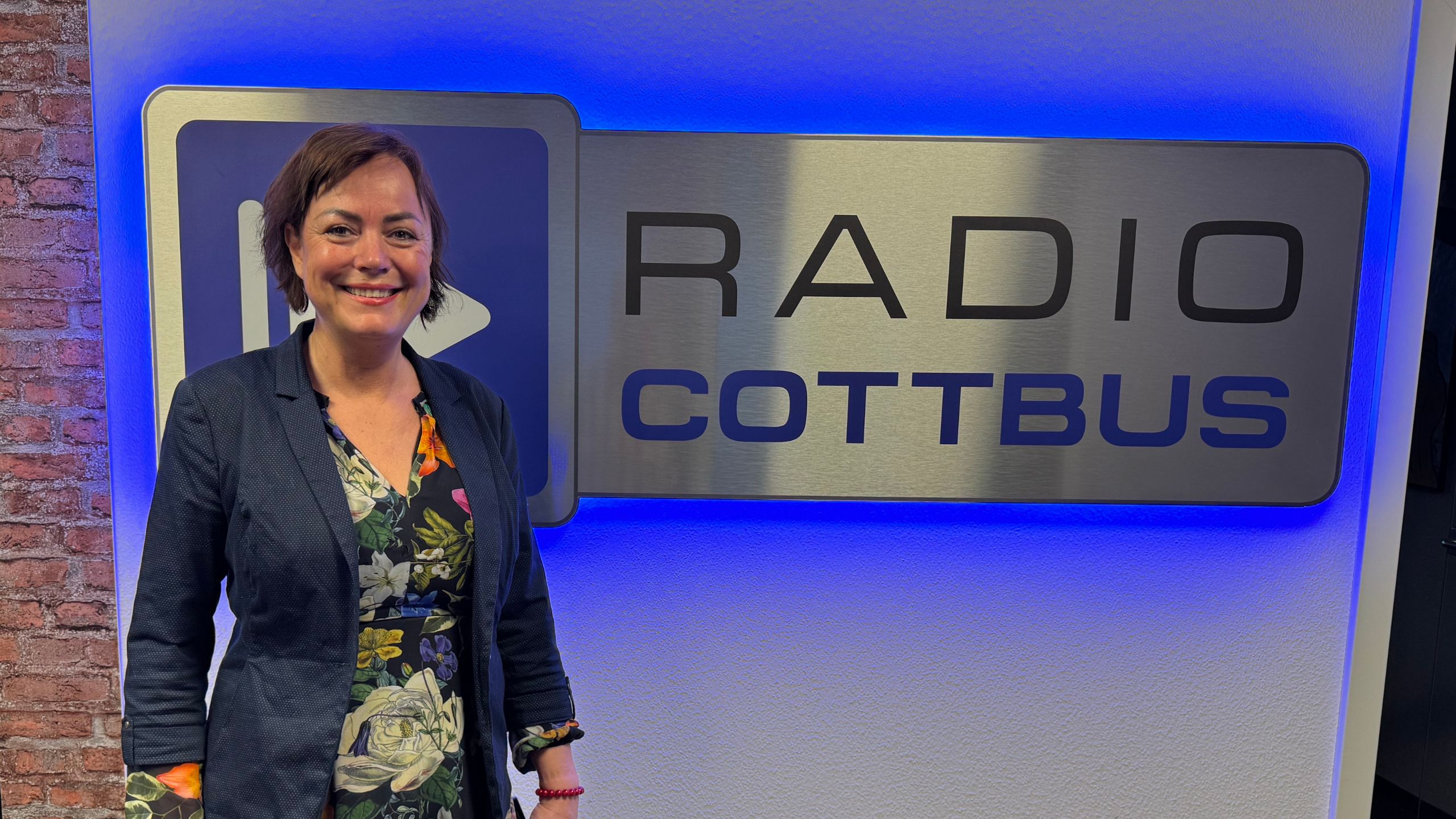 Mandy Sprejz bei Radio Cottbus vor dem Radio Cottbus Schild