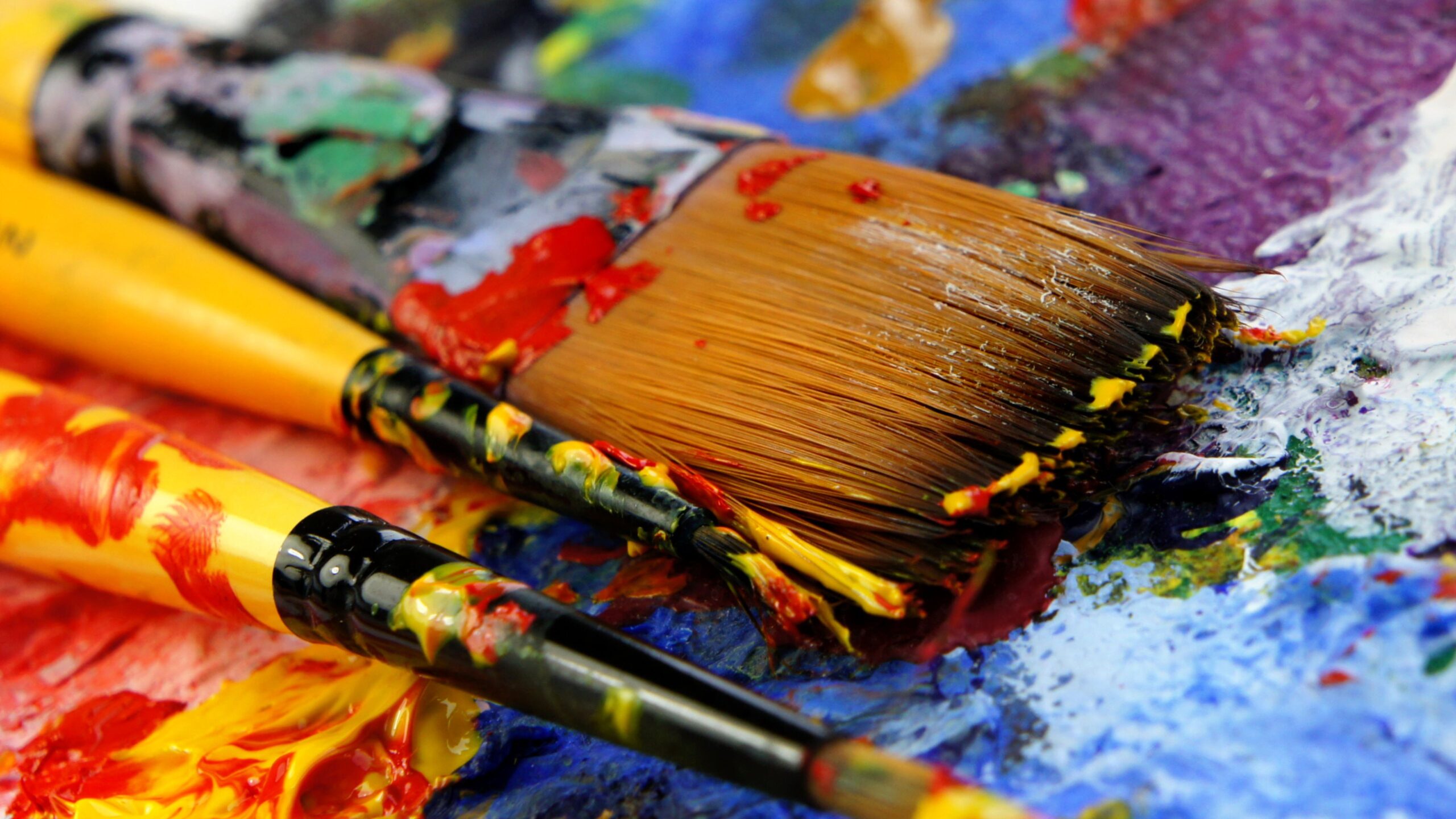 Pinsel mit Farbe liegen auf einer Mischpalette
