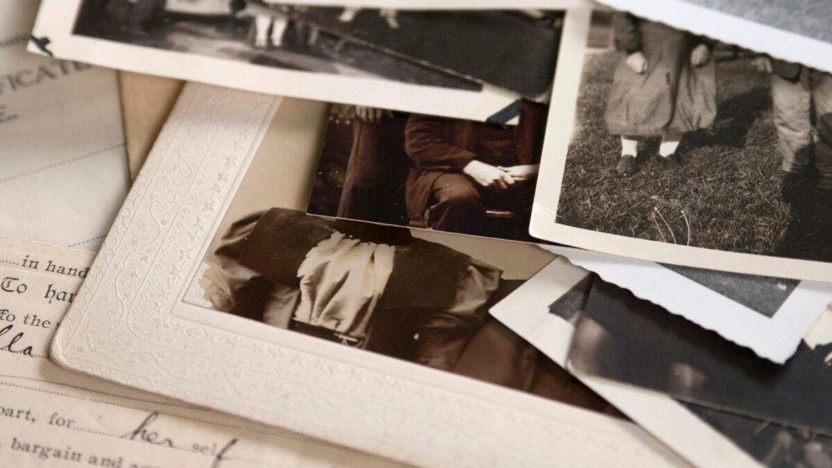 Einige Fotos in Schwarz-Weiß, die auf einem alten Schriftstück liegen
