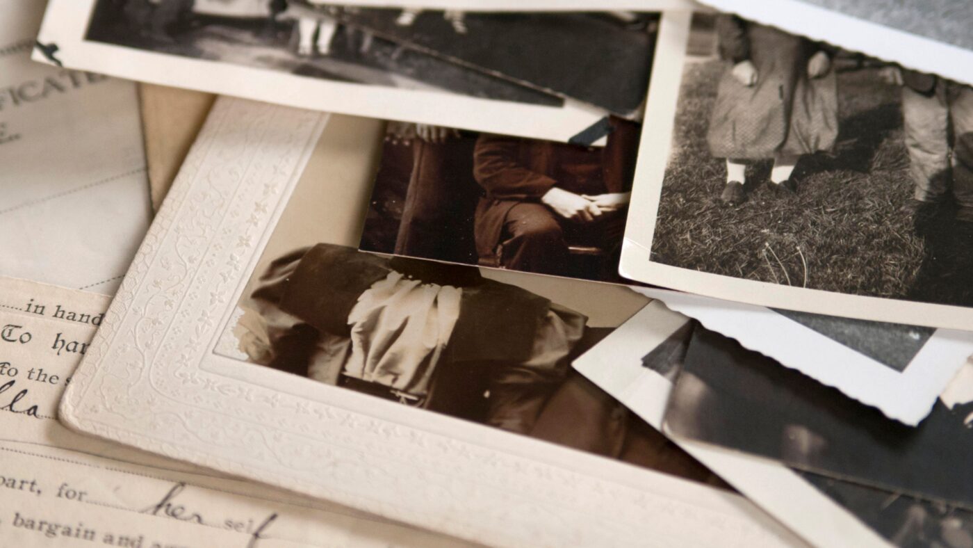 Einige Fotos in Schwarz-Weiß, die auf einem alten Schriftstück liegen