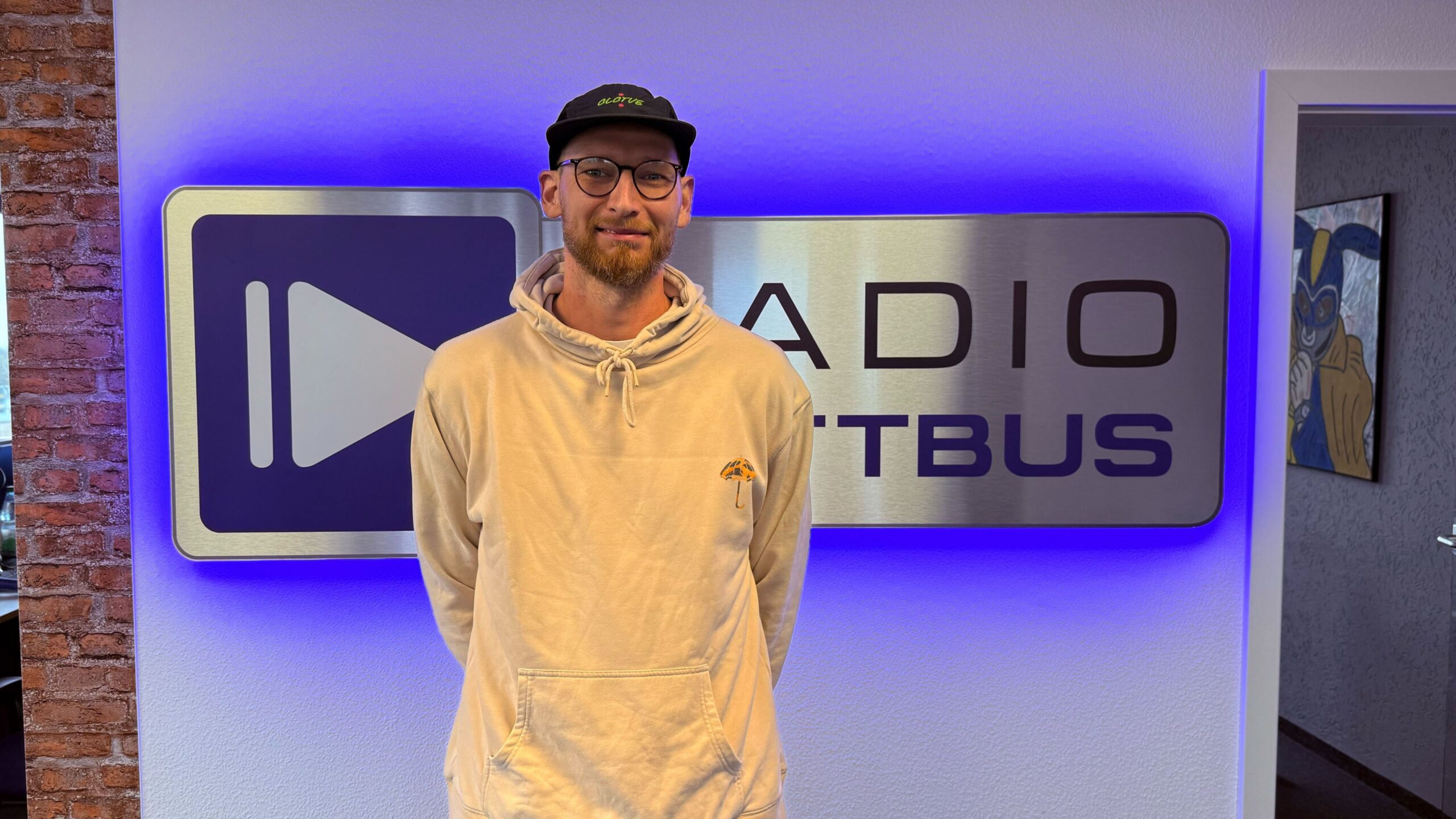 Marcus Werner vom Cottbus Wheels e.V. vor dem Radio Cottbus Logo