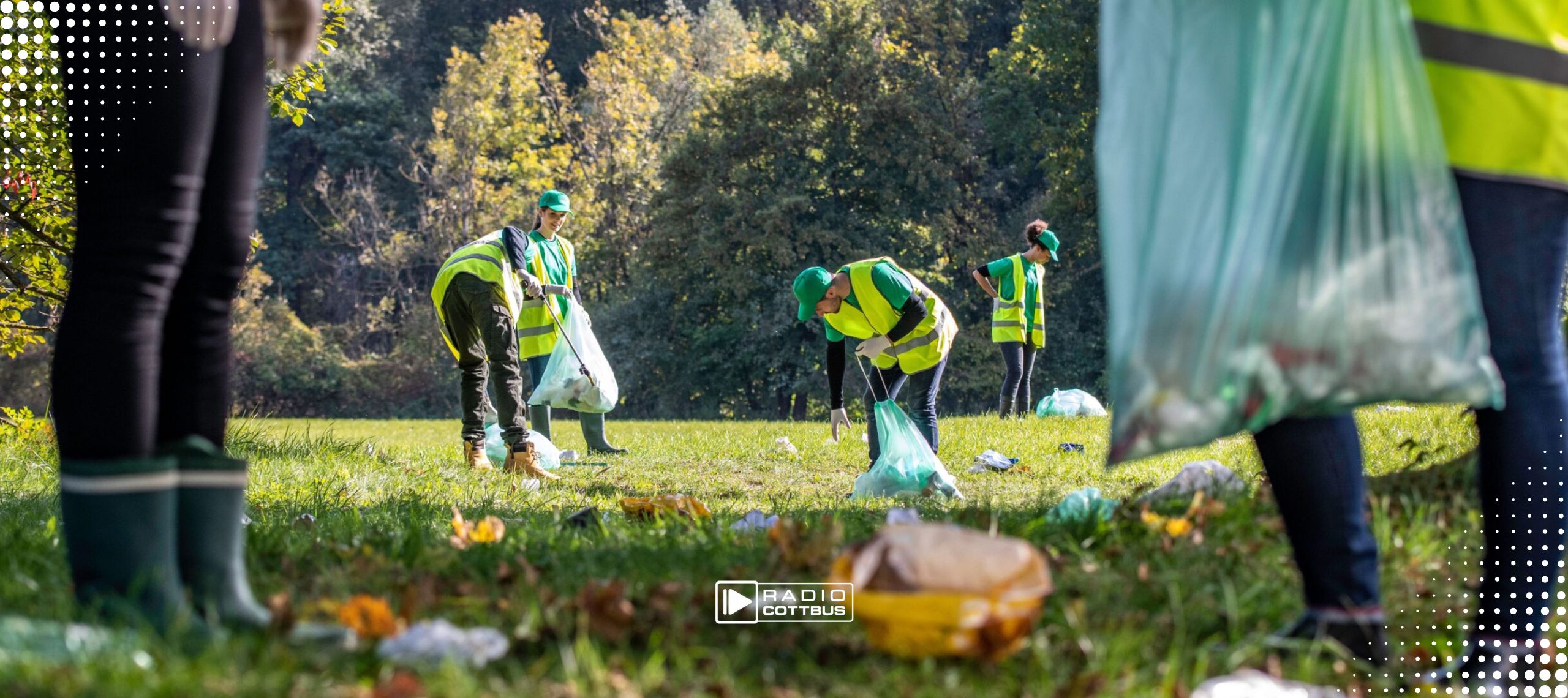 Mehrere Menschen mit grünen Warnwesten räumen einen Park auf mit Müllbeuteln und Müll-Zangen