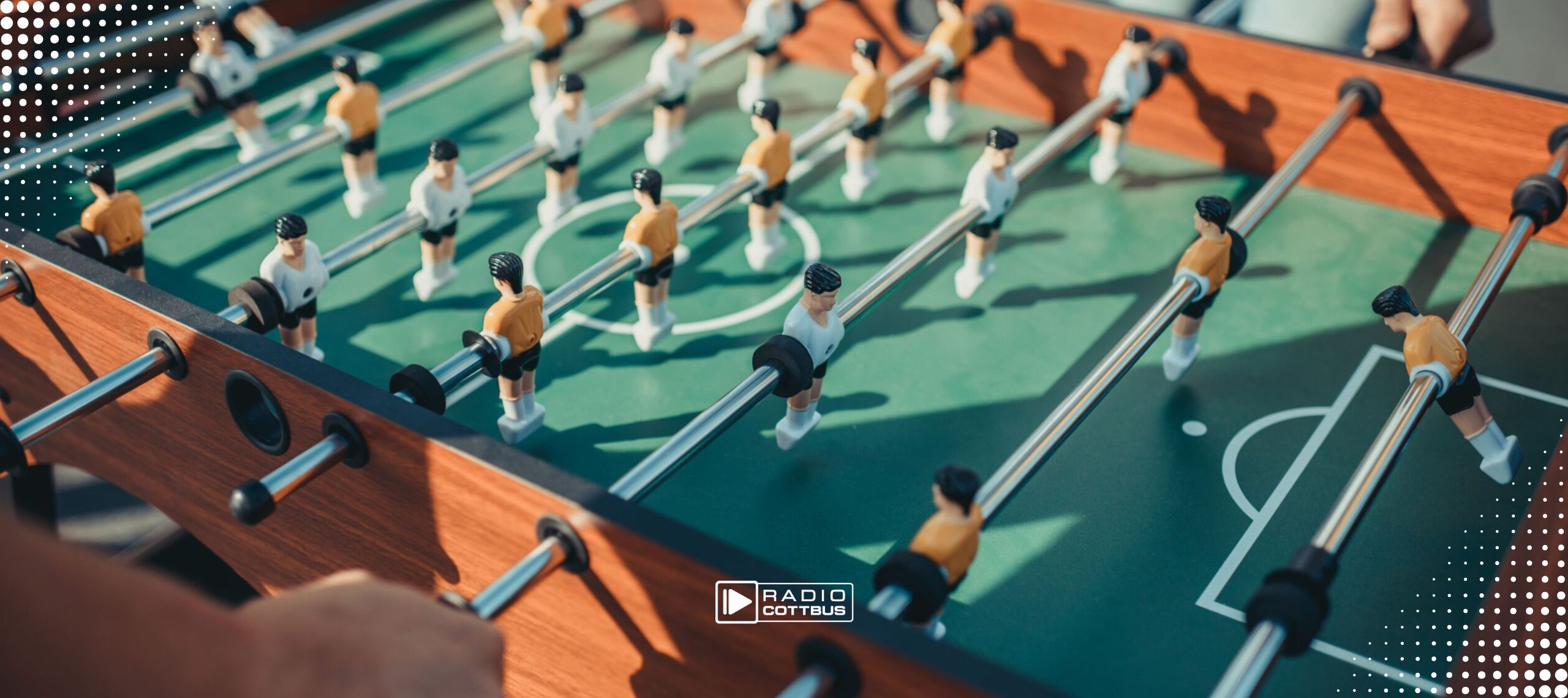 Zwei Männer spielen Tischkicker gegeneinander, man sieht nur ihre Hände und den Tischkicker mit den Figuren