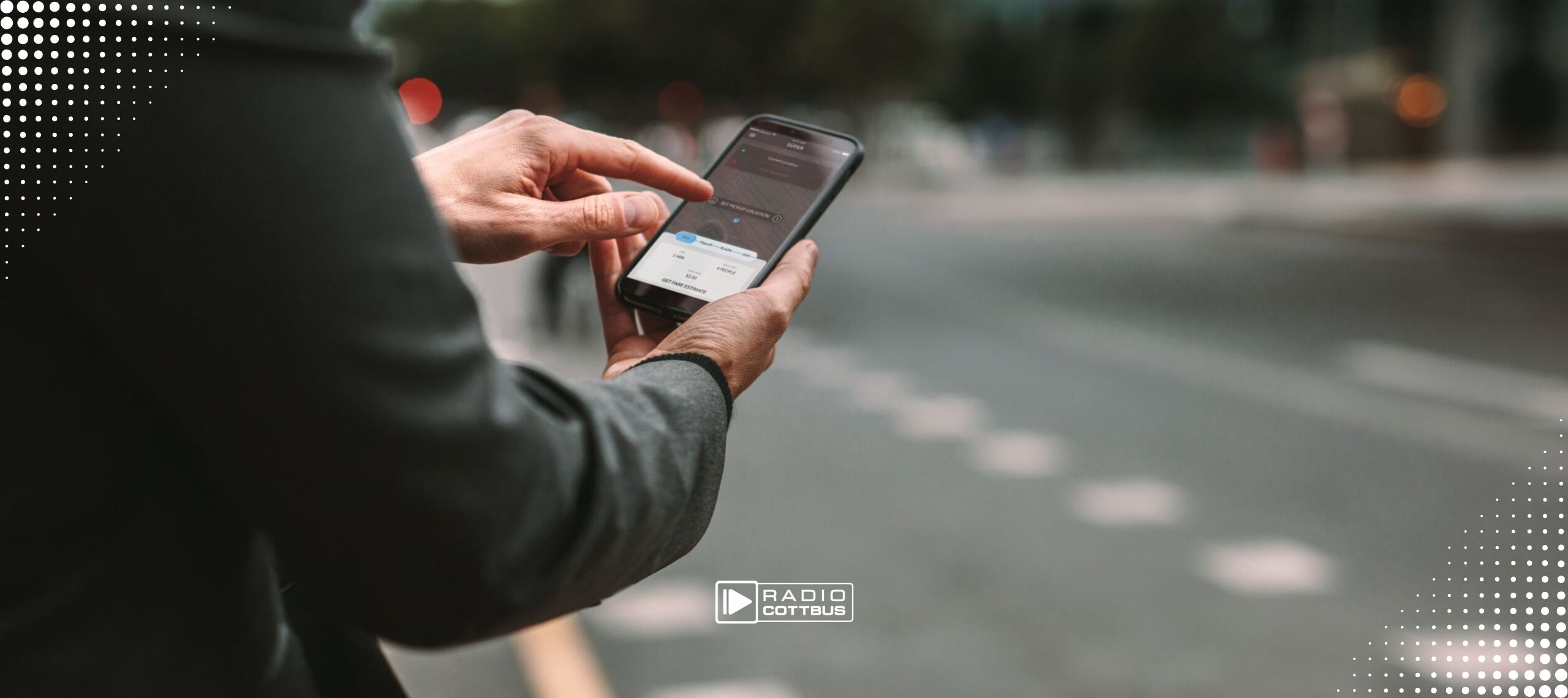 Ein Mann an einer Straße, der sein Handy in der Hand hält und darauf etwas anklickt