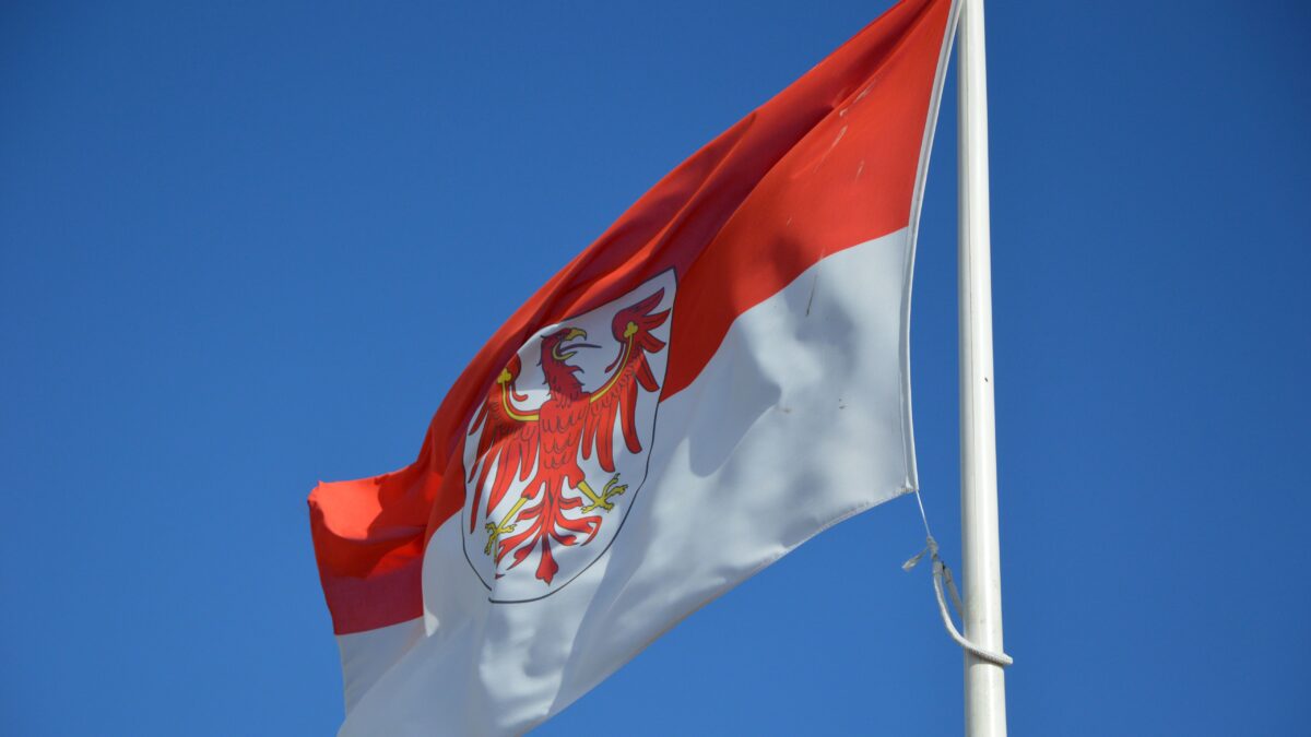Die rot-weiße Brandenburg Flagge mit dem Adler weht an einem Fahnenmast