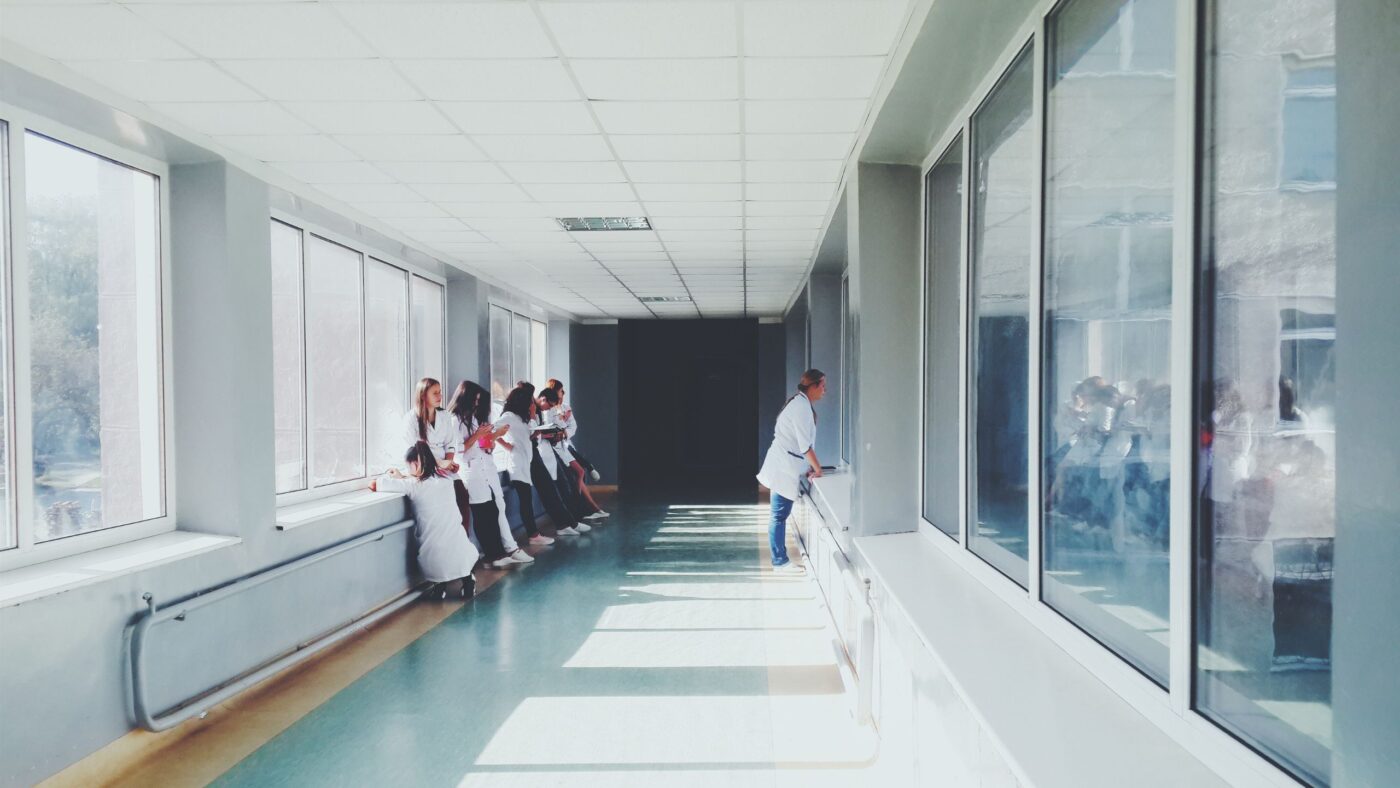 ein Krankenhausflur in dem mehrere Leute sitzen