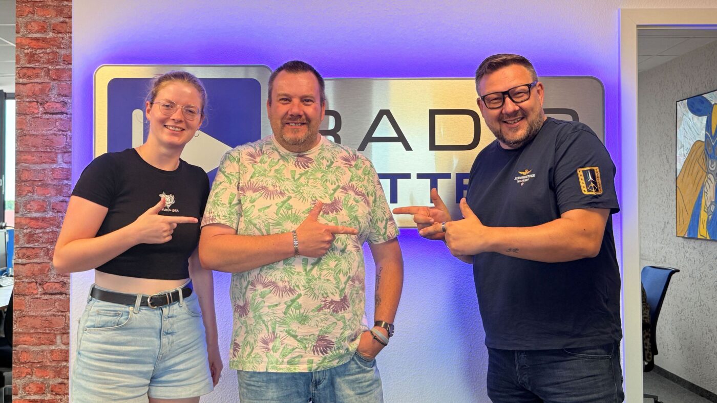 Martin Borscht von Blaulichtreport mit den Wacher Machern Luka Stadelmaier und Ronny Gersch vor dem Radio Cottbus Logo