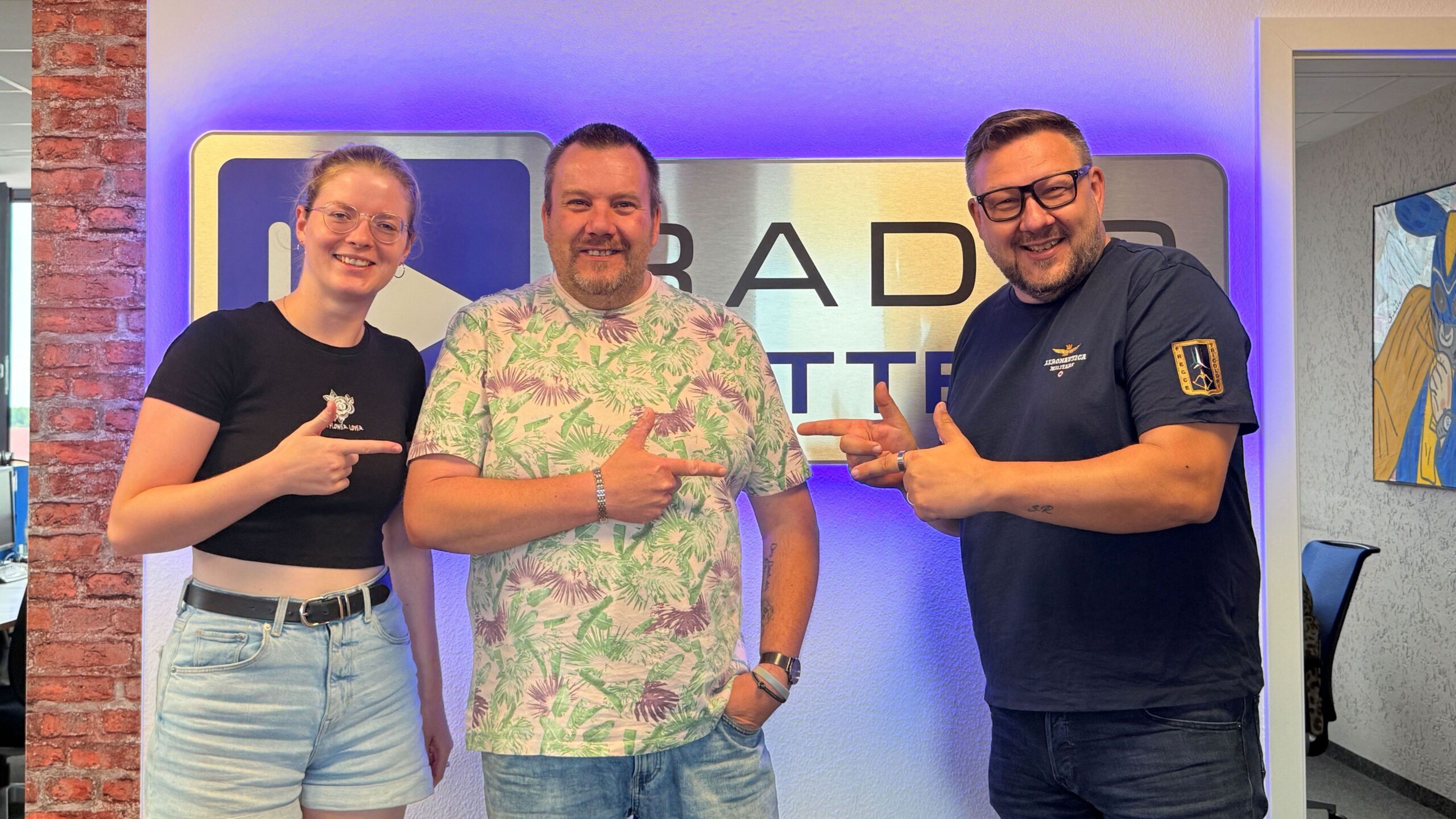 Martin Borscht von Blaulichtreport mit den Wacher Machern Luka Stadelmaier und Ronny Gersch vor dem Radio Cottbus Logo