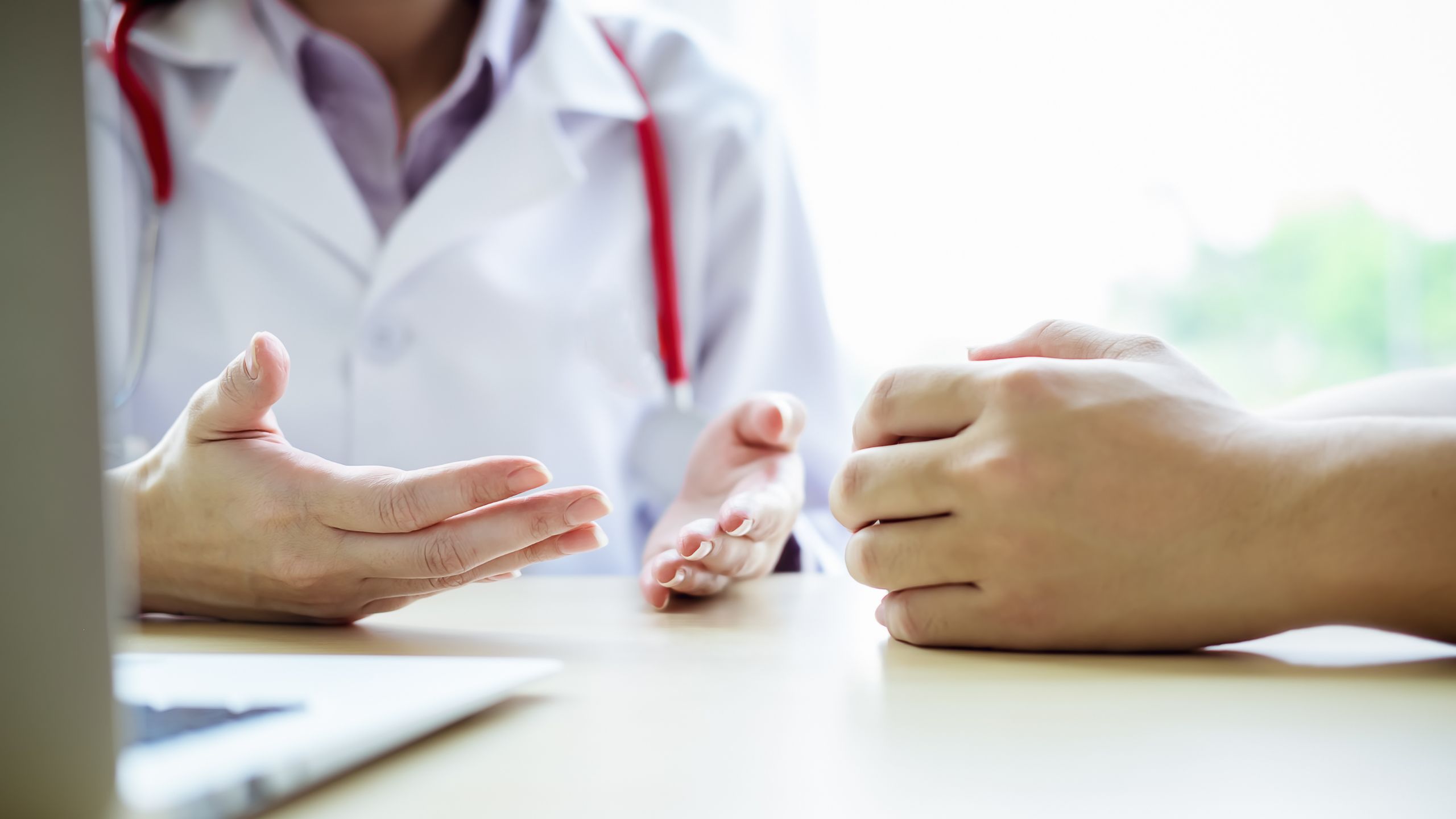 Arzt, sitz mit seinem Patient am Tisch und spricht