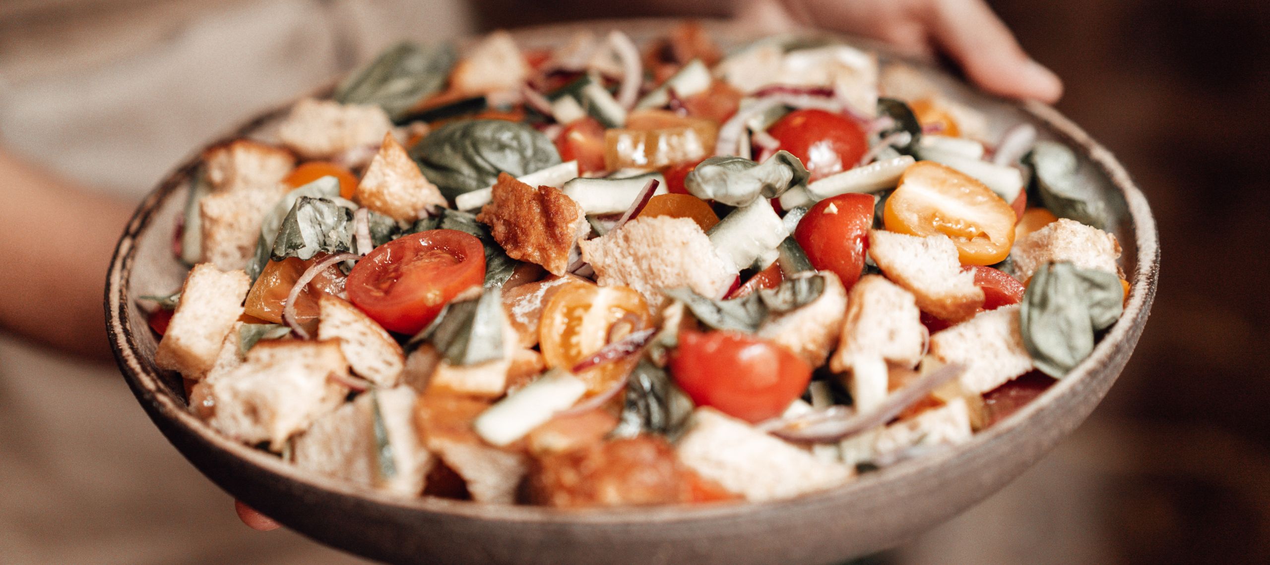Italienischer Panzanellasalat wird in einer Schüssel präsentiert