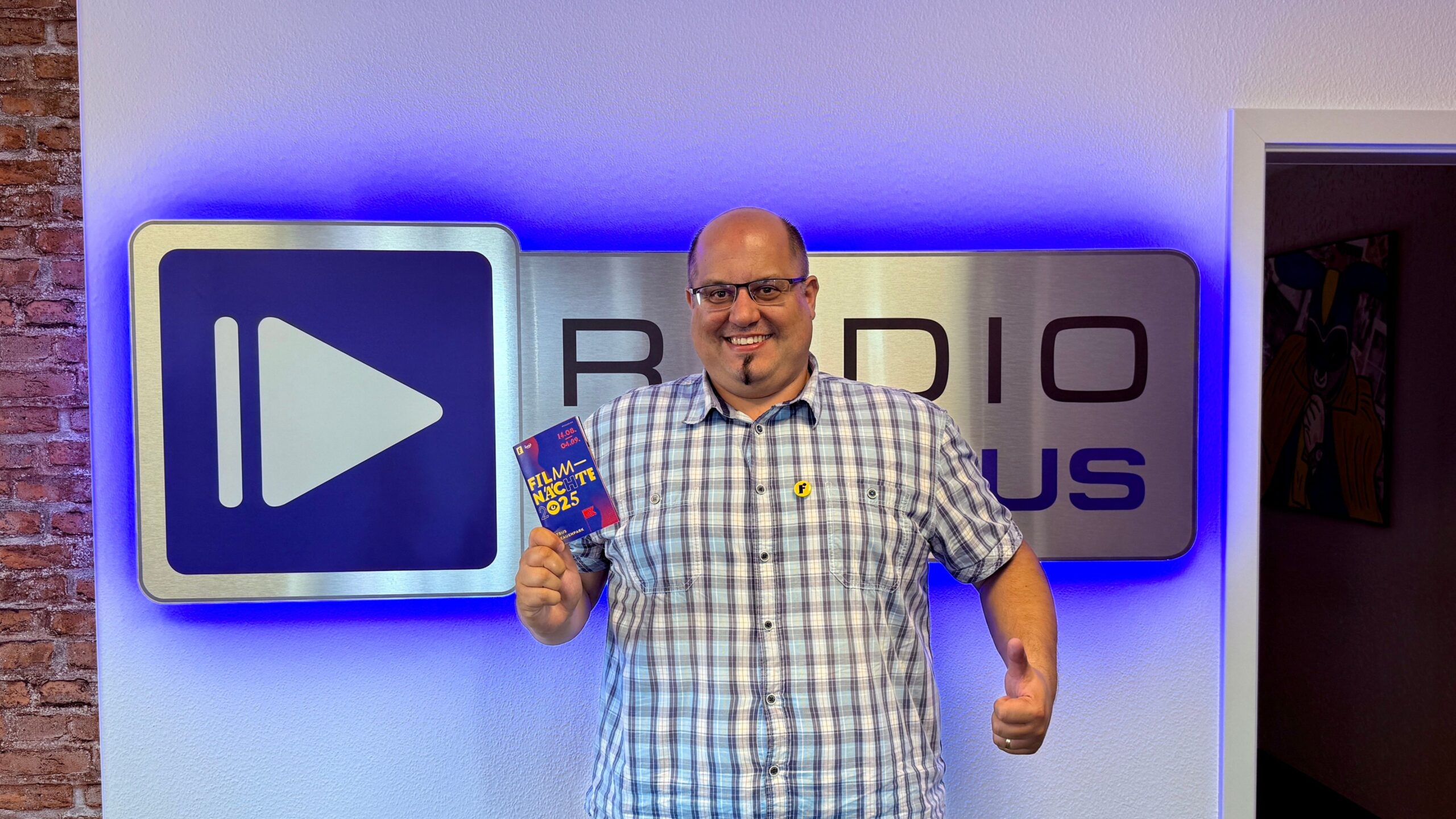 Manuel Unger steht vor dem Radio Cottbus Logo