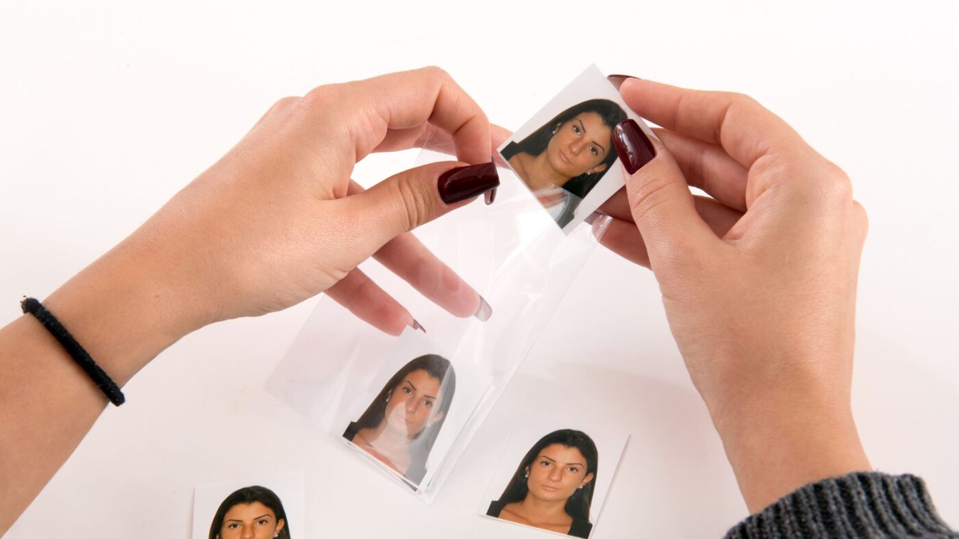 Identitätsdiebstahl durch Passfotos, Hände halten Passfotos