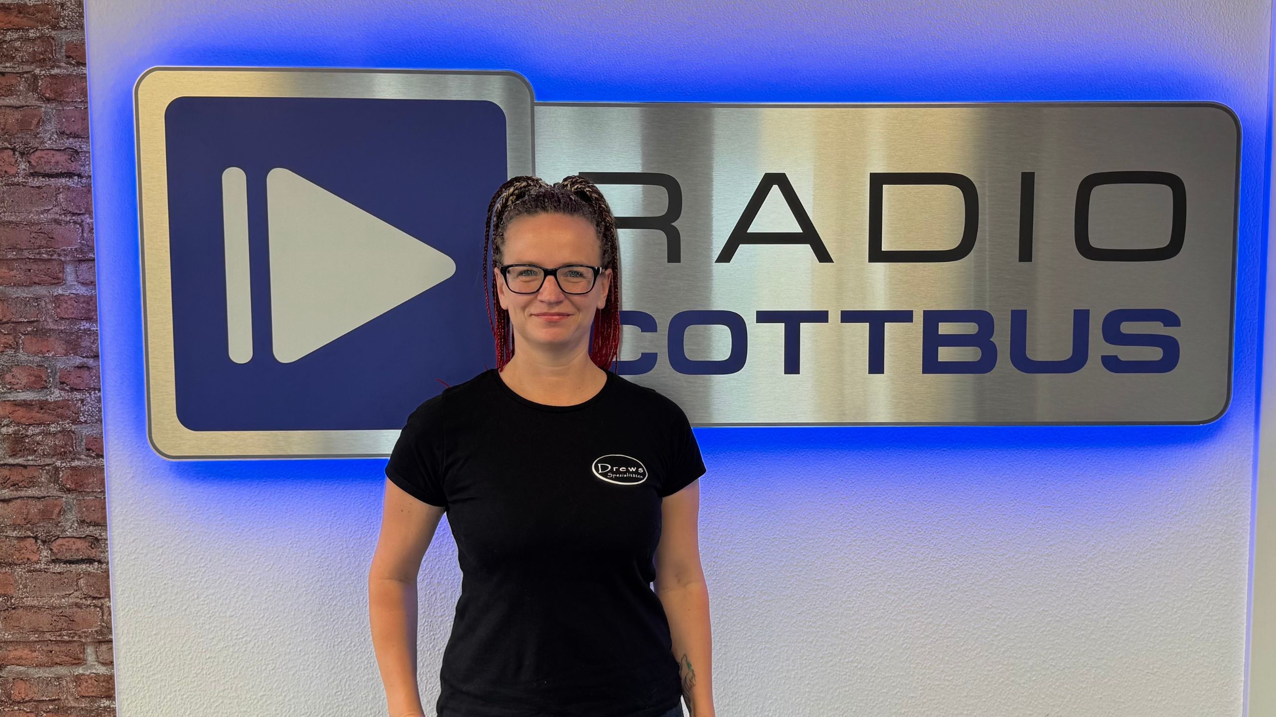 Unsere Chefin on Air von Drews Spezialitäten Getränkefachmarkt Constanze Jünigk vor dem Radio Cottbus Logo