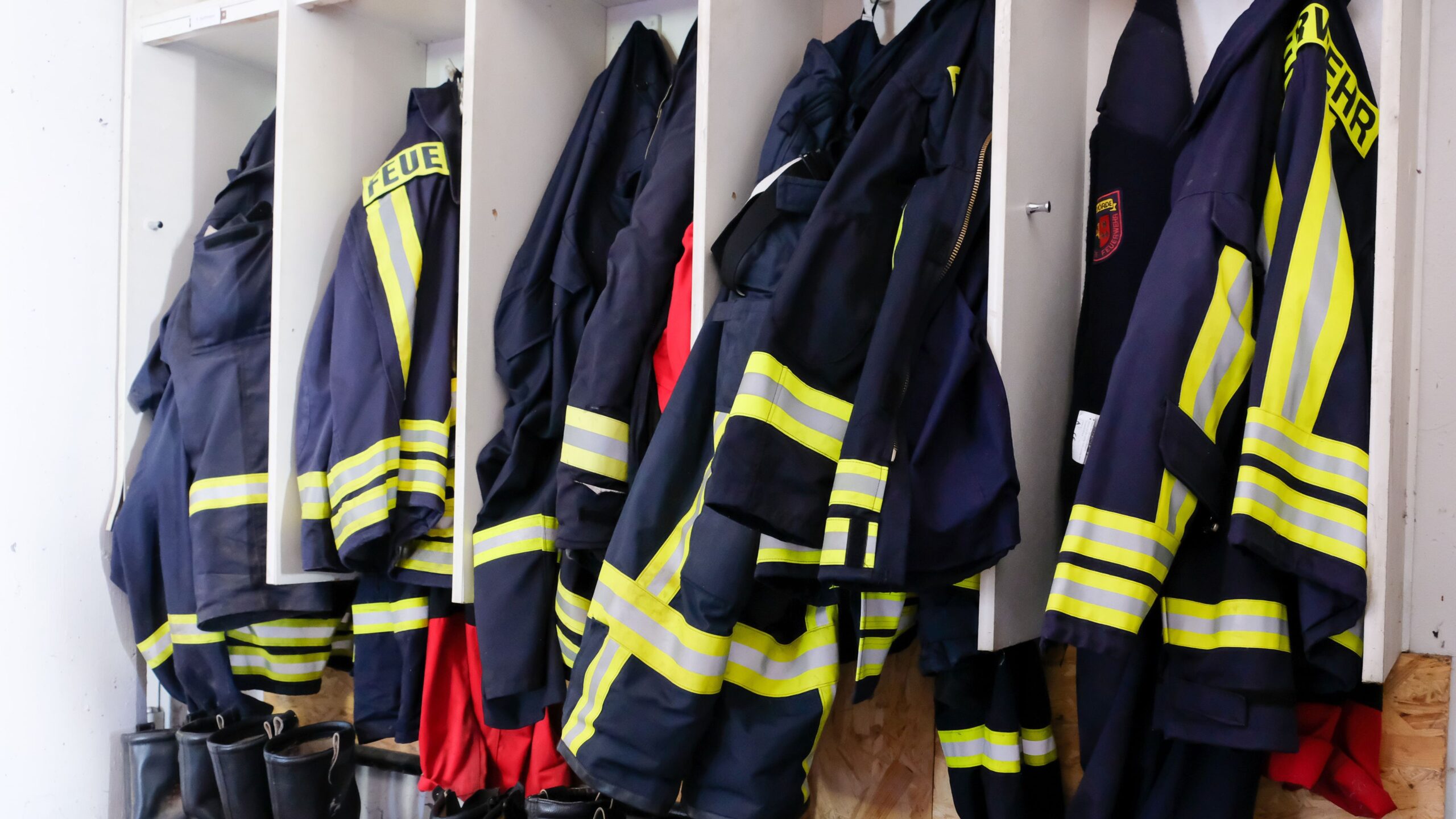 Bild von Feuerwehranzügen aufgehangen in fünf Fächern