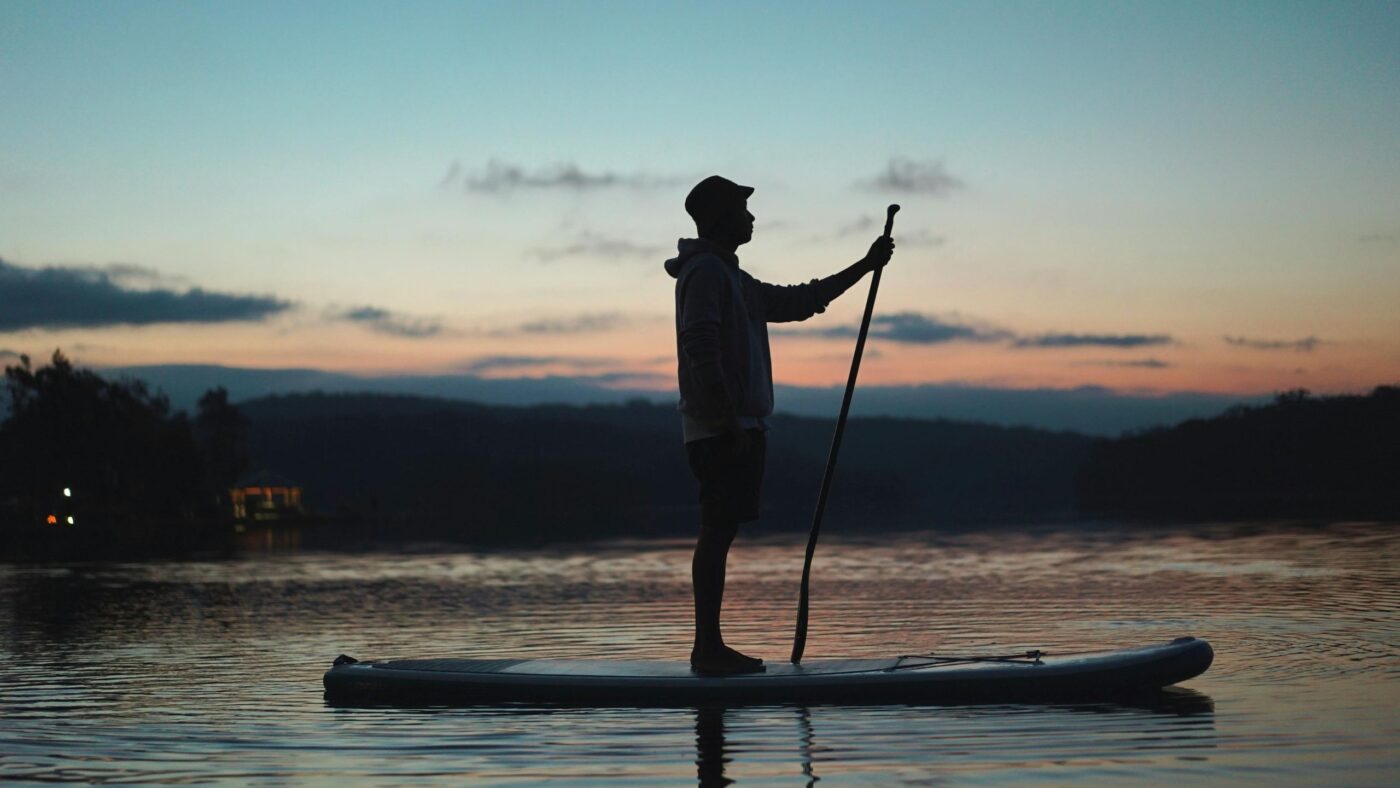 Stand Up Paddler auf einem See bei Sonnenuntergang