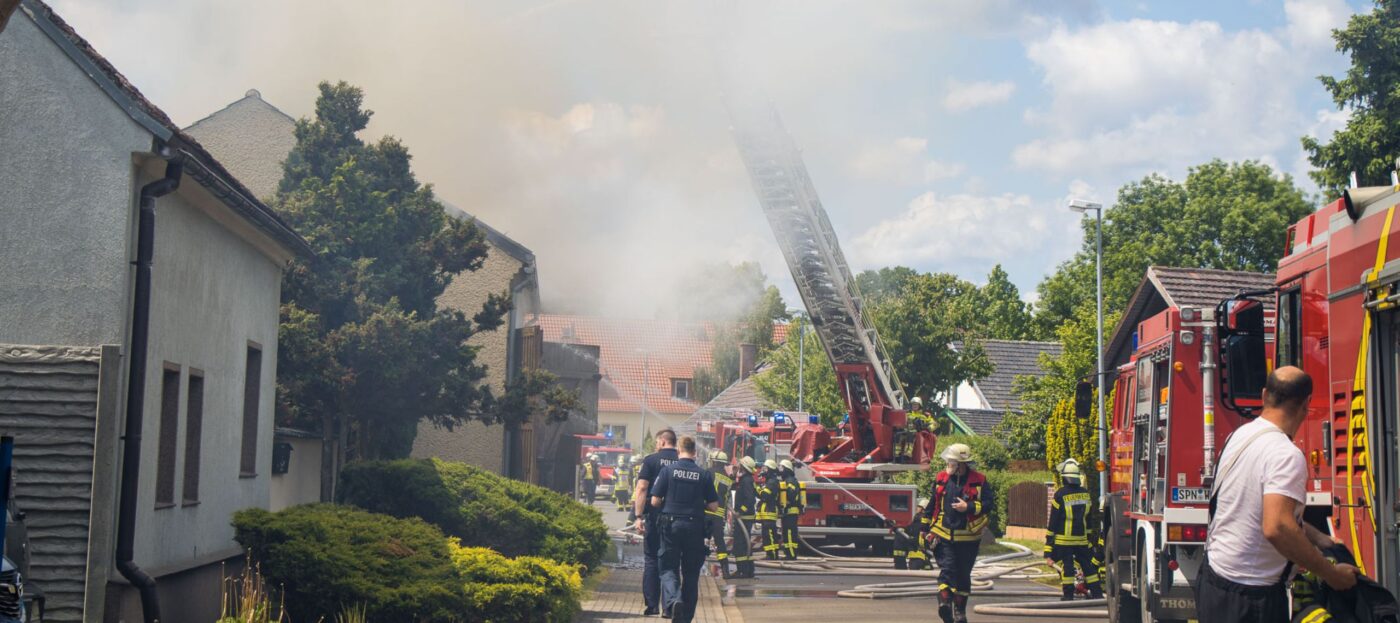 Ein Einfamilienhaus in Dissen steht am 26.05.2025 in Flammen und wird von der Feuerwehr vor dem Haus gelöscht. Eine Drehleiter kommt zum Einsatz.
