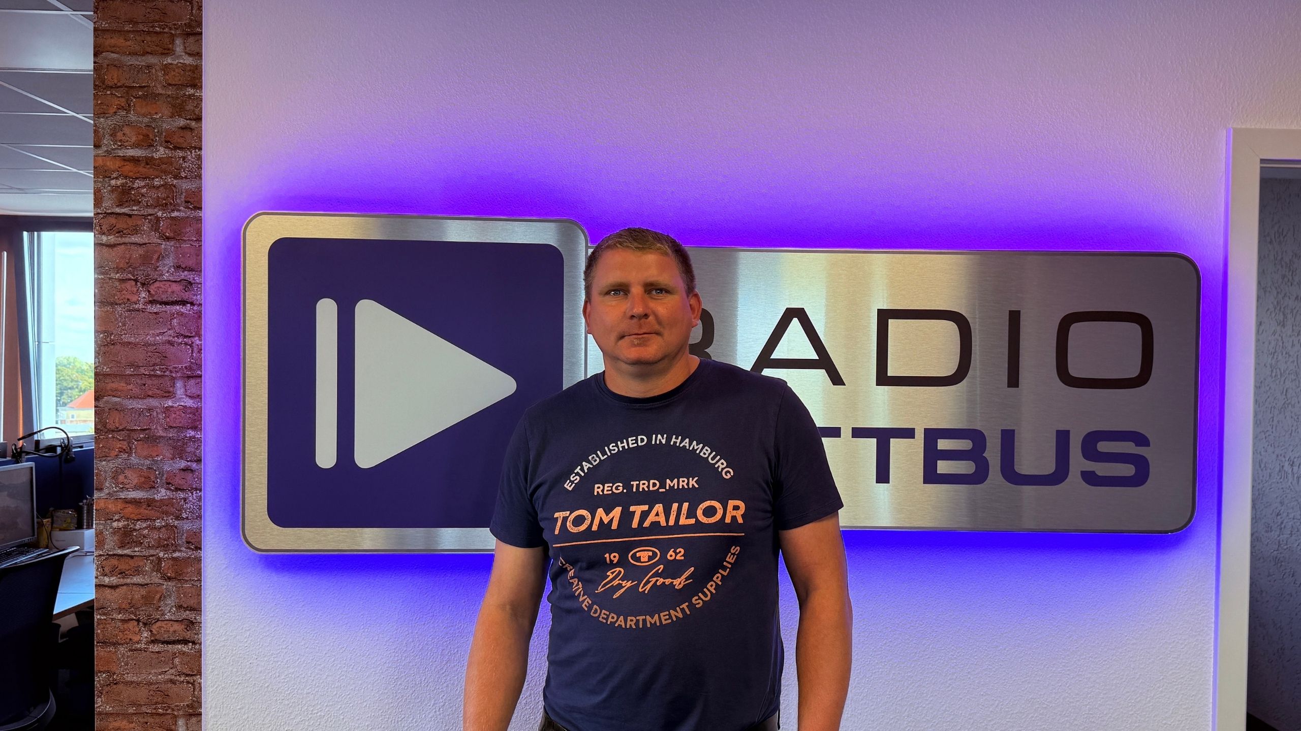 Matthias Trentzsch von Lausitzer Seenland Safran vor dem Radio Cottbus Logo