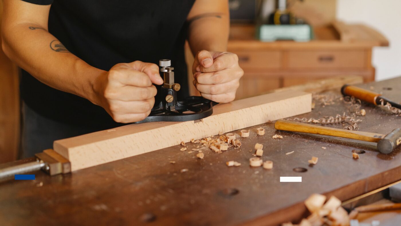 Ein Mann spannt einen Holzblock auf einem Werktisch ein