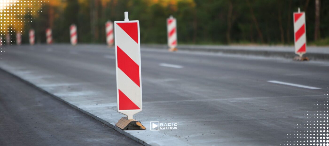 Mehrere Baustellenpfeiler an einer frisch asphaltierten neuen Straße