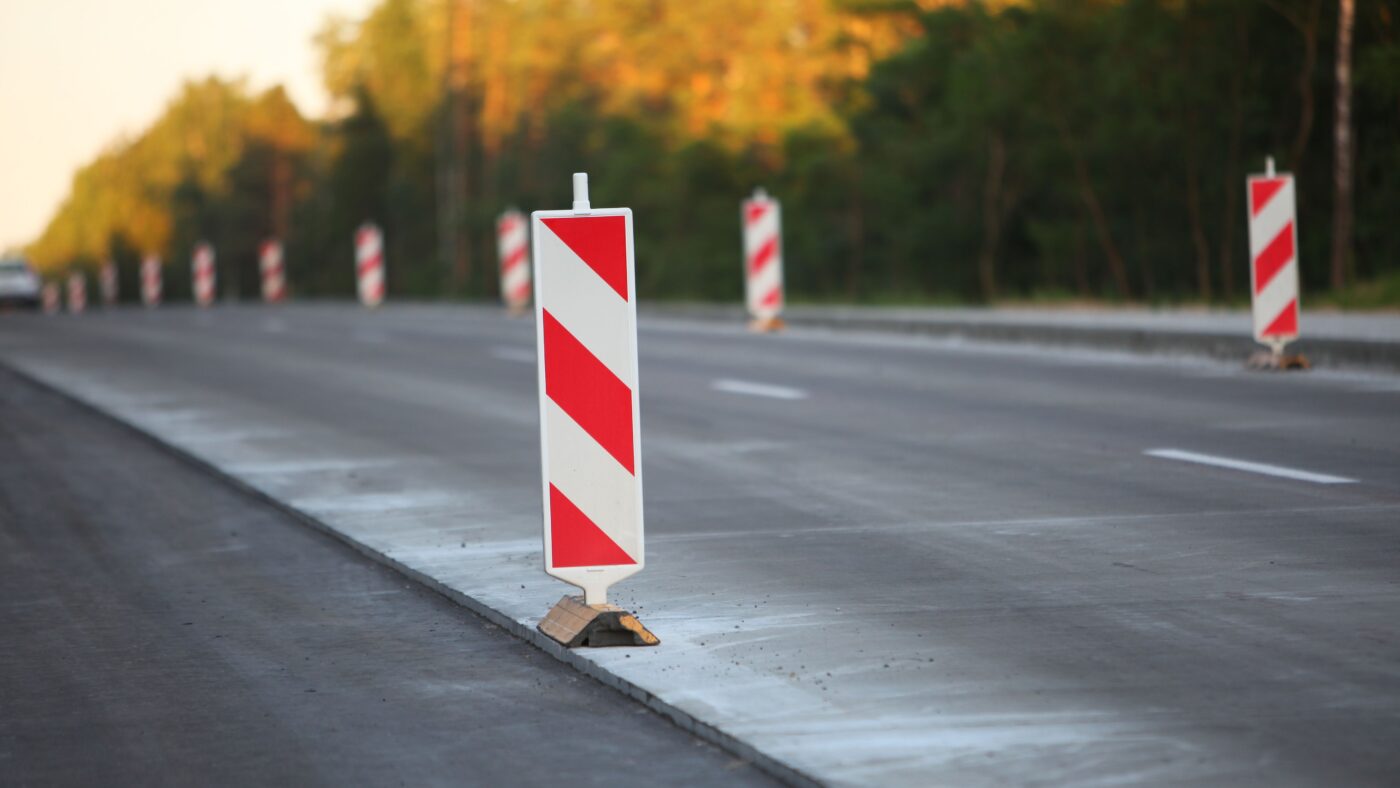 Mehrere Baustellenpfeiler an einer frisch asphaltierten neuen Straße