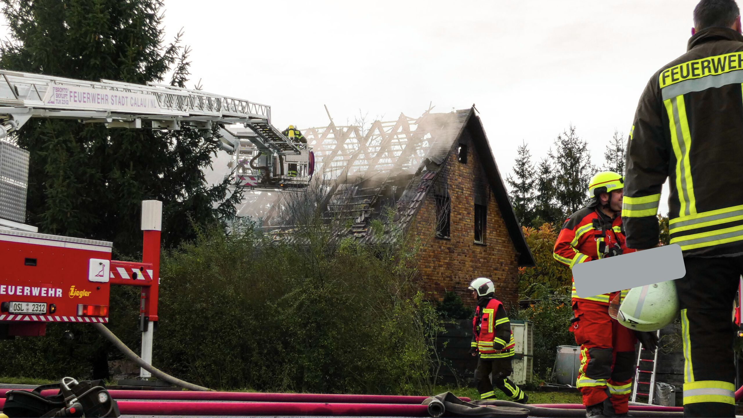 Die Feuerwehr löscht einen Brand bei einem Einfamilienhaus