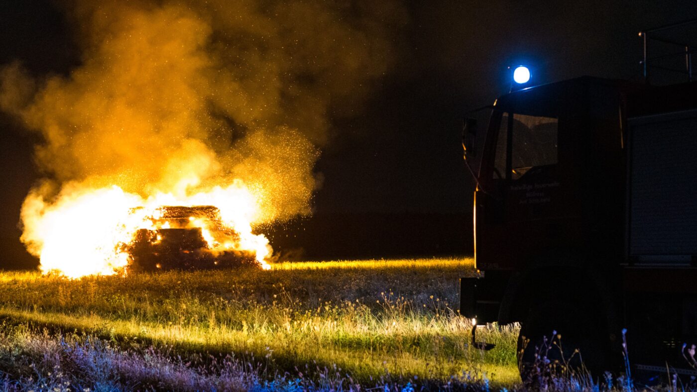 Eine Strohmiete in Groß Kölzig brennt lichterloh und ein Feuerwehrauto steht davor