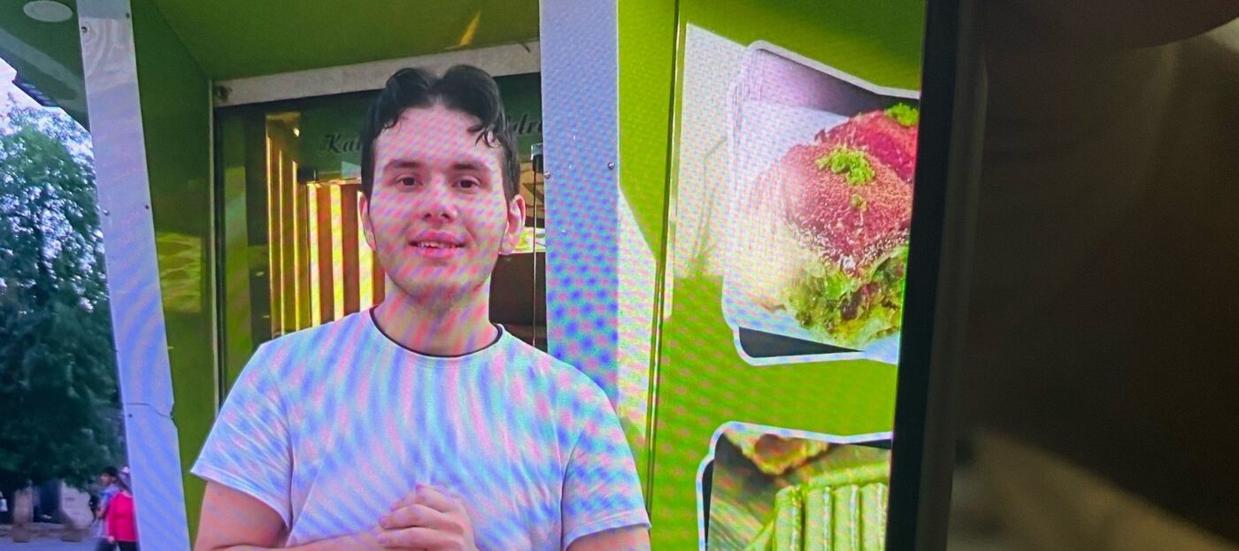Der vermisste Bilal A. aus Cottbus, nach dem die Polizei gerade fahndet, steht vor einem grünen Gebäude und lächelt in die Kamera