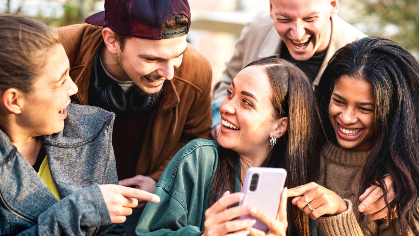 Gruppe Jugendlicher die auf ein Handy schauen