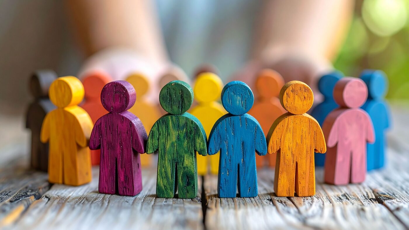 Mehrere bunte Holzfiguren bilden einen Kreis