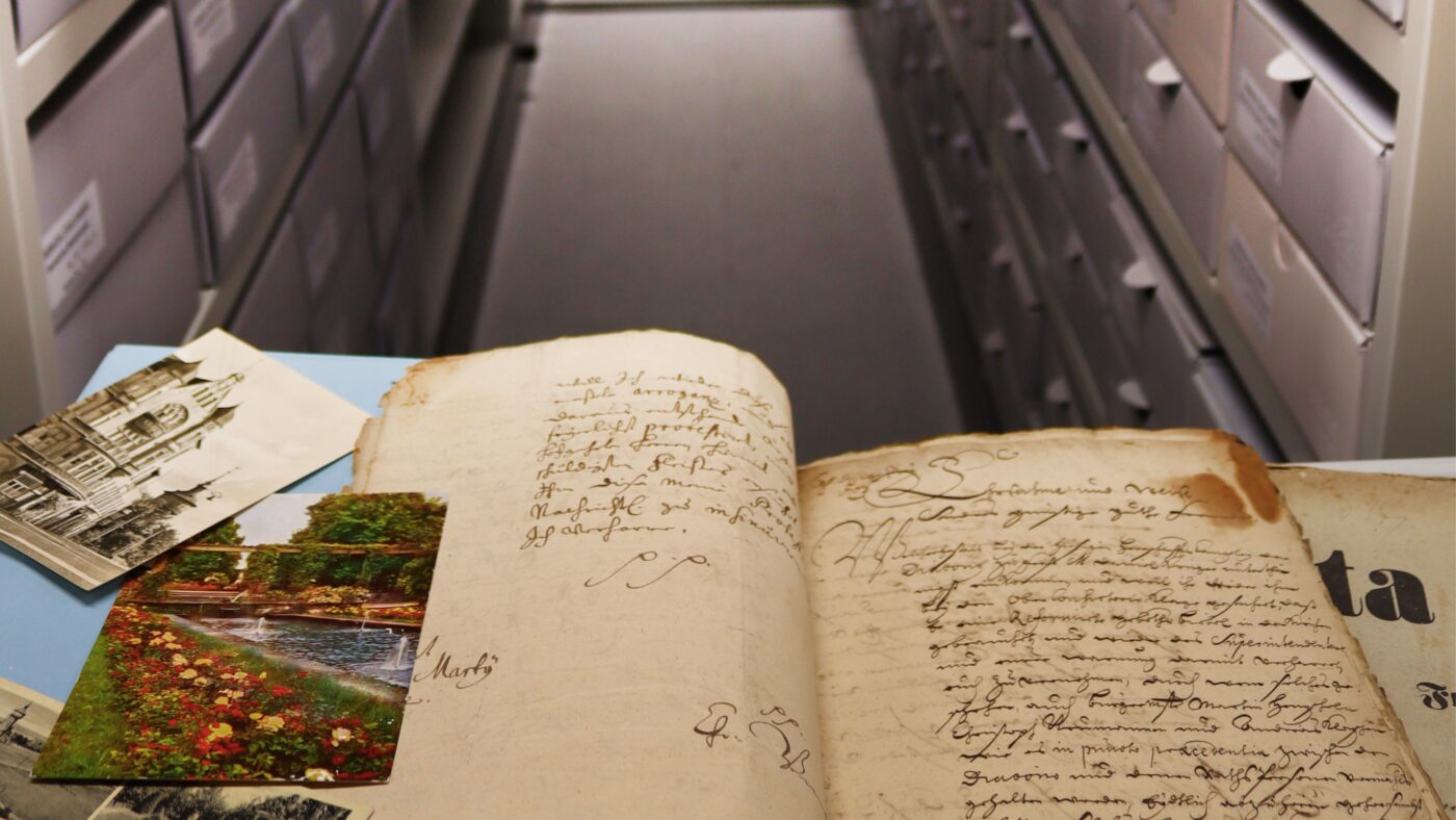 Eröffnung des Forster Stadtarchivs - ein altes Buch mit ein paar Fotos und dahinter das neue Archiv