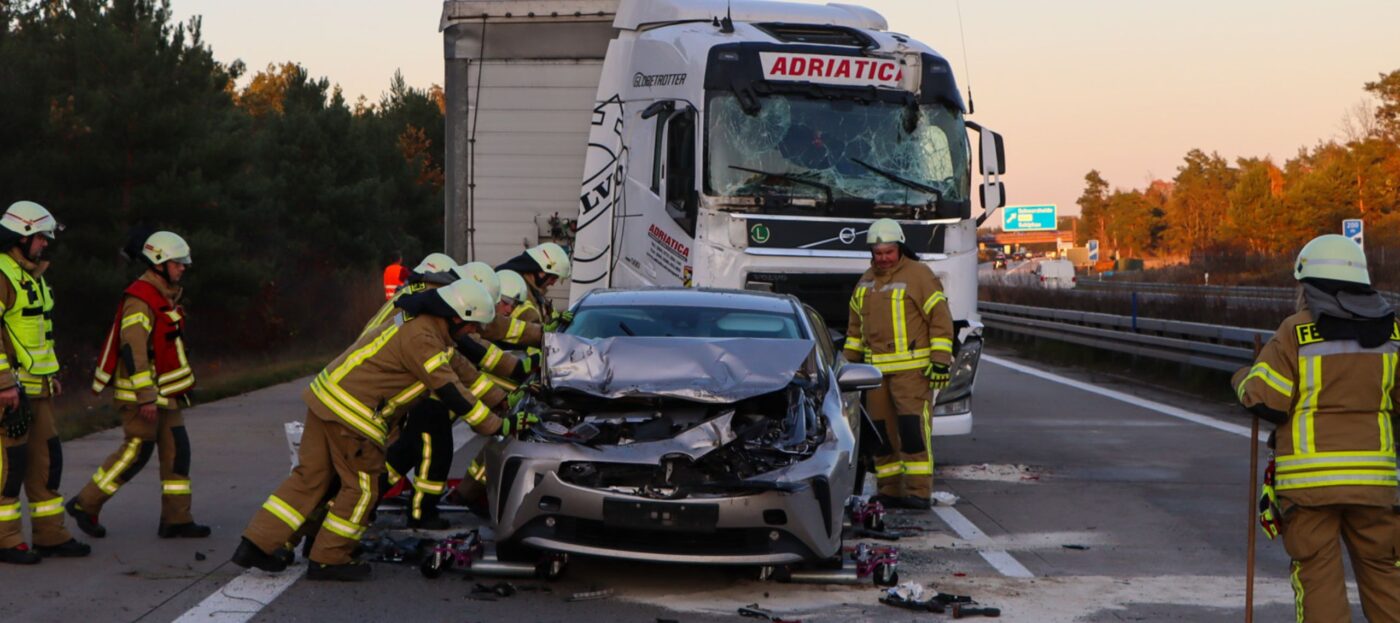 Ein völlig zerstörter PKW steht auf der Autobahn A13 nach einem Unfall mit zwei LKW. Hinter ihm steht der LKW, der aufgefahren ist und ebenfalls schwer beschädigt ist