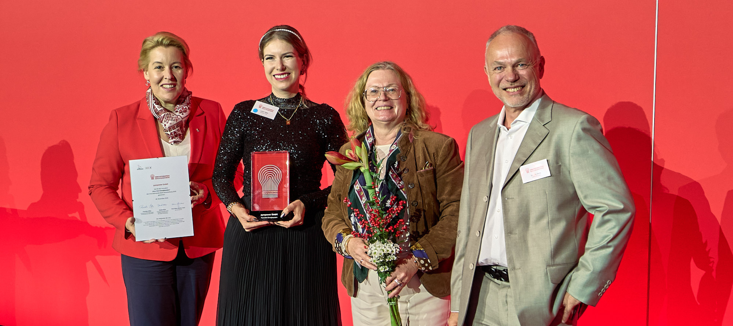 Der Innovationspreis 2025 geht an Lucie Töpfer von der Pyropower GmbH aus Cottbus, die den Preis auf der Bühne in den Händen hält