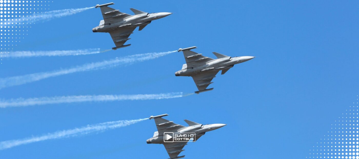 Drei Kampfjets fliegen am blauen Himmel und ziehen Spuren hinter sich her