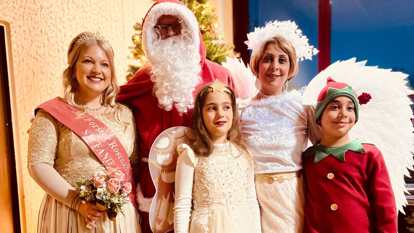 Der Weihnachtsmann, die Forster Rosenkönigin und zwei Kinder bei der Wunschbaumaktion in Forst 2025