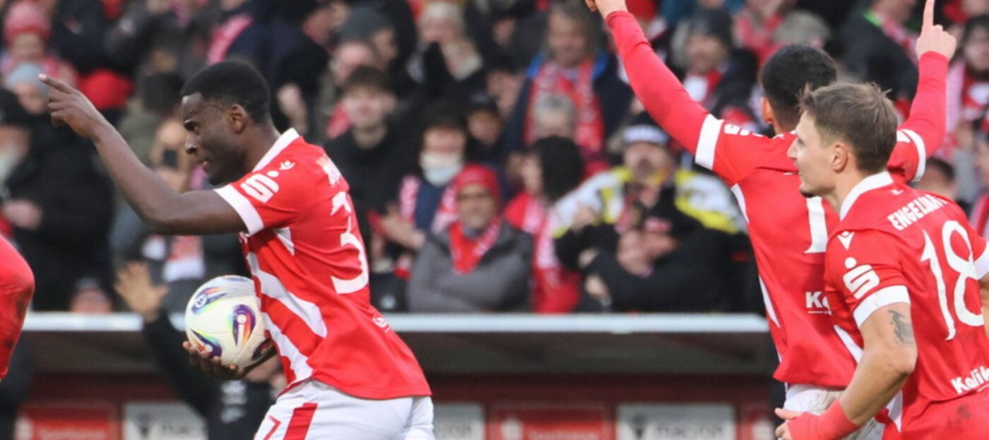 Die Spieler des FC Energie Cottbus Biankadi, Engelhardt und Cigerci jubeln nach einem Tor. Biankadi hat sich den Ball geschnappt und läuft Richtung Mittellinie.