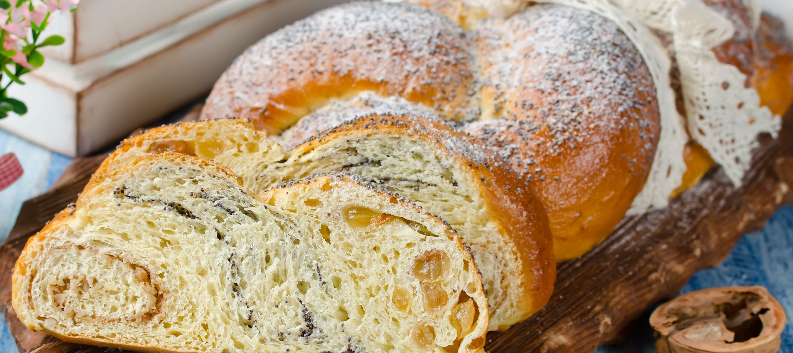 Ein frisch augeschnittener Hefezopf liegt auf einem Holzbrett