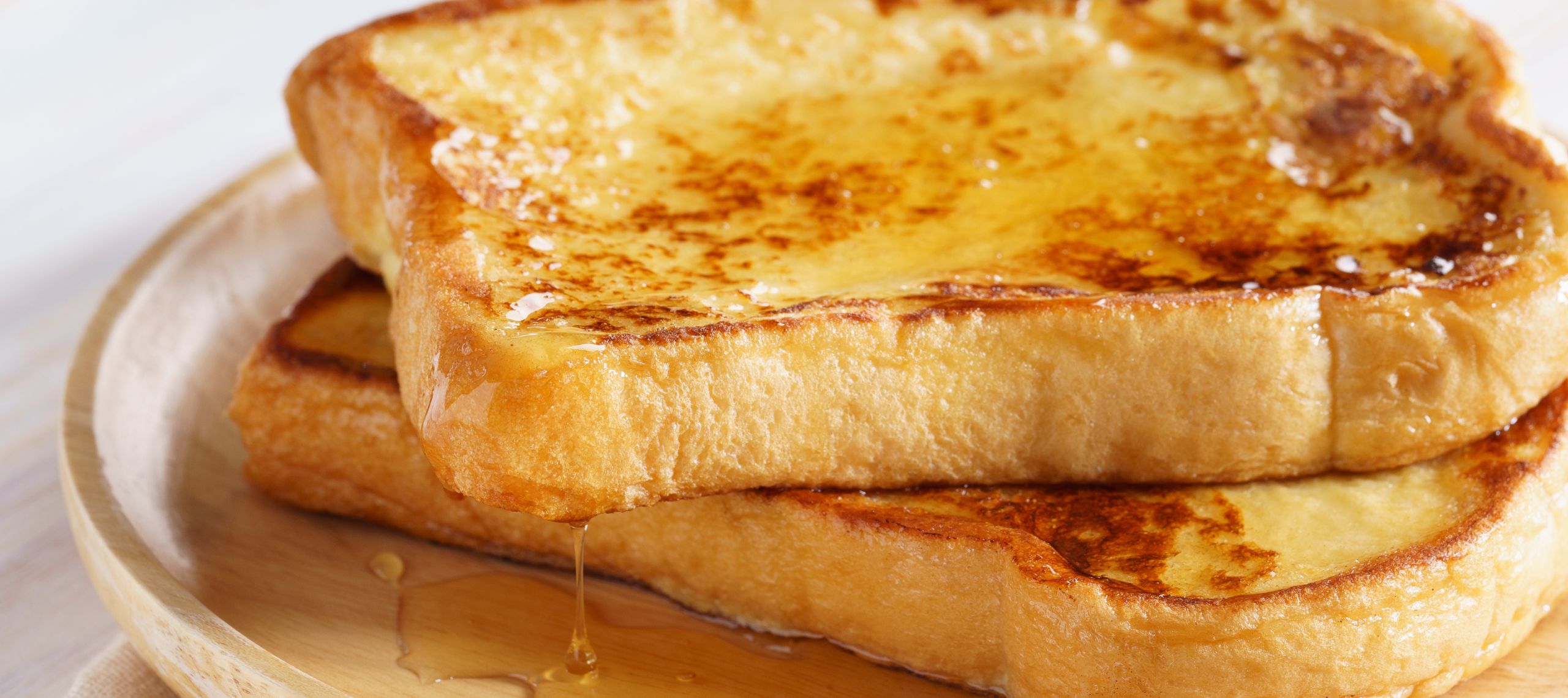 Arme Ritter liegen auf einem Teller und werden mit geschmolzener Butter serviert in Pücklers Parkküche