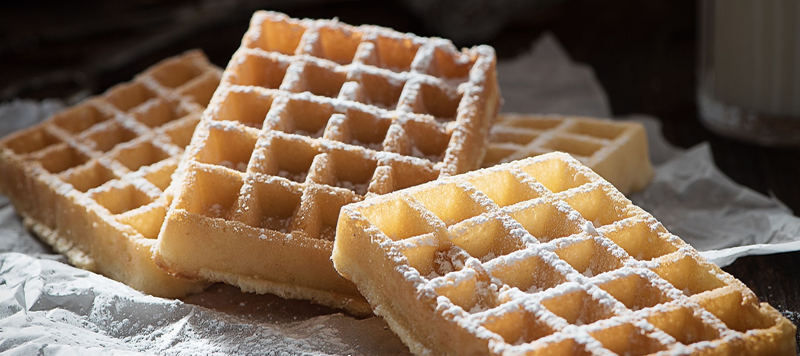 Puderzucker wird auf Waffeln aus Kartoffeln und aus klassischem Teig gestreut