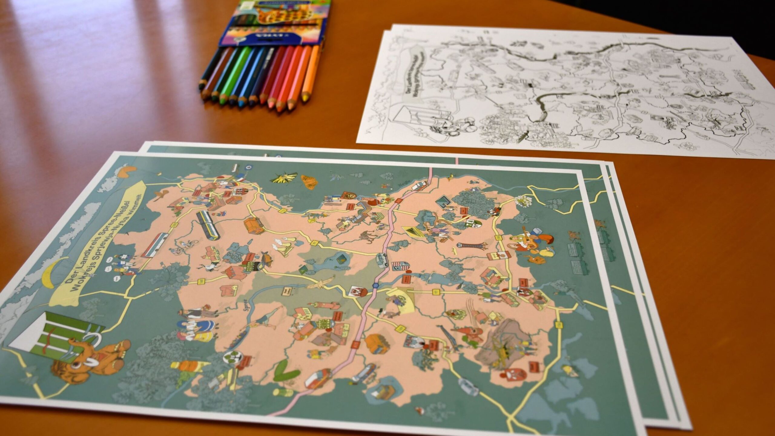 Wimmelbild des Landkreises in zweifacher Ausführung: bunt oder zum Ausmalen