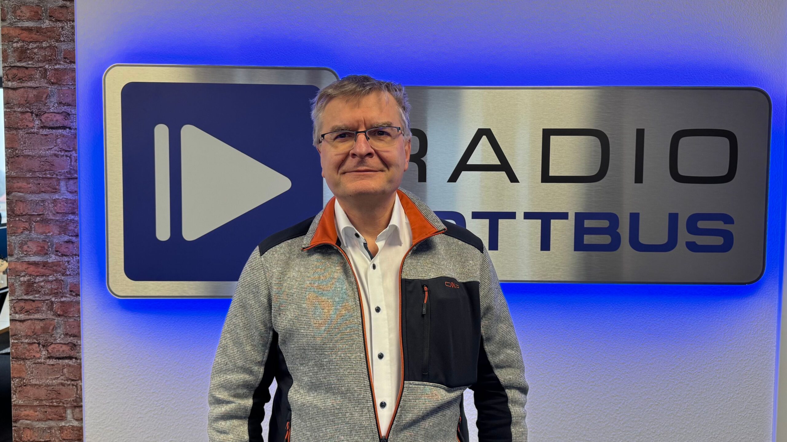 Matthias Kaiser vor dem Radio Cottbus Logo