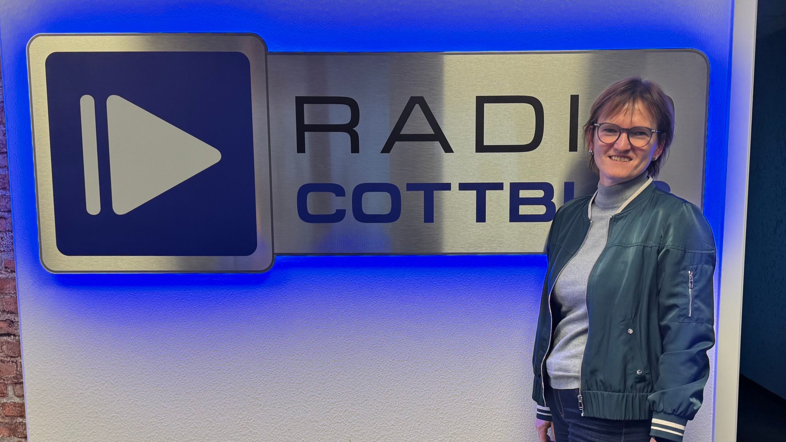 Kerstin Schulz vor dem Radio Cottbus Logo