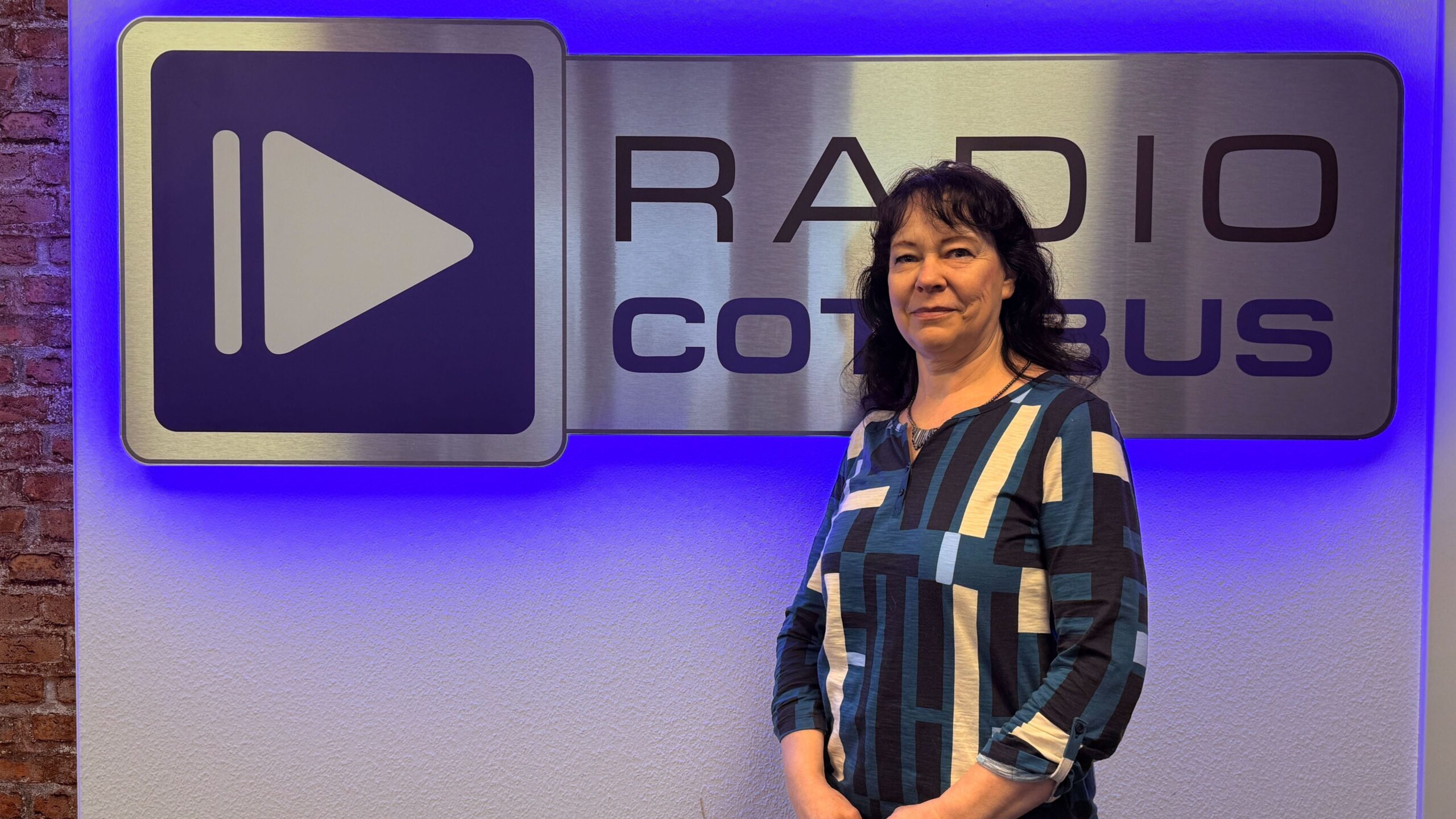 Katrin Zeptner vor dem Radio Cottbus Logo
