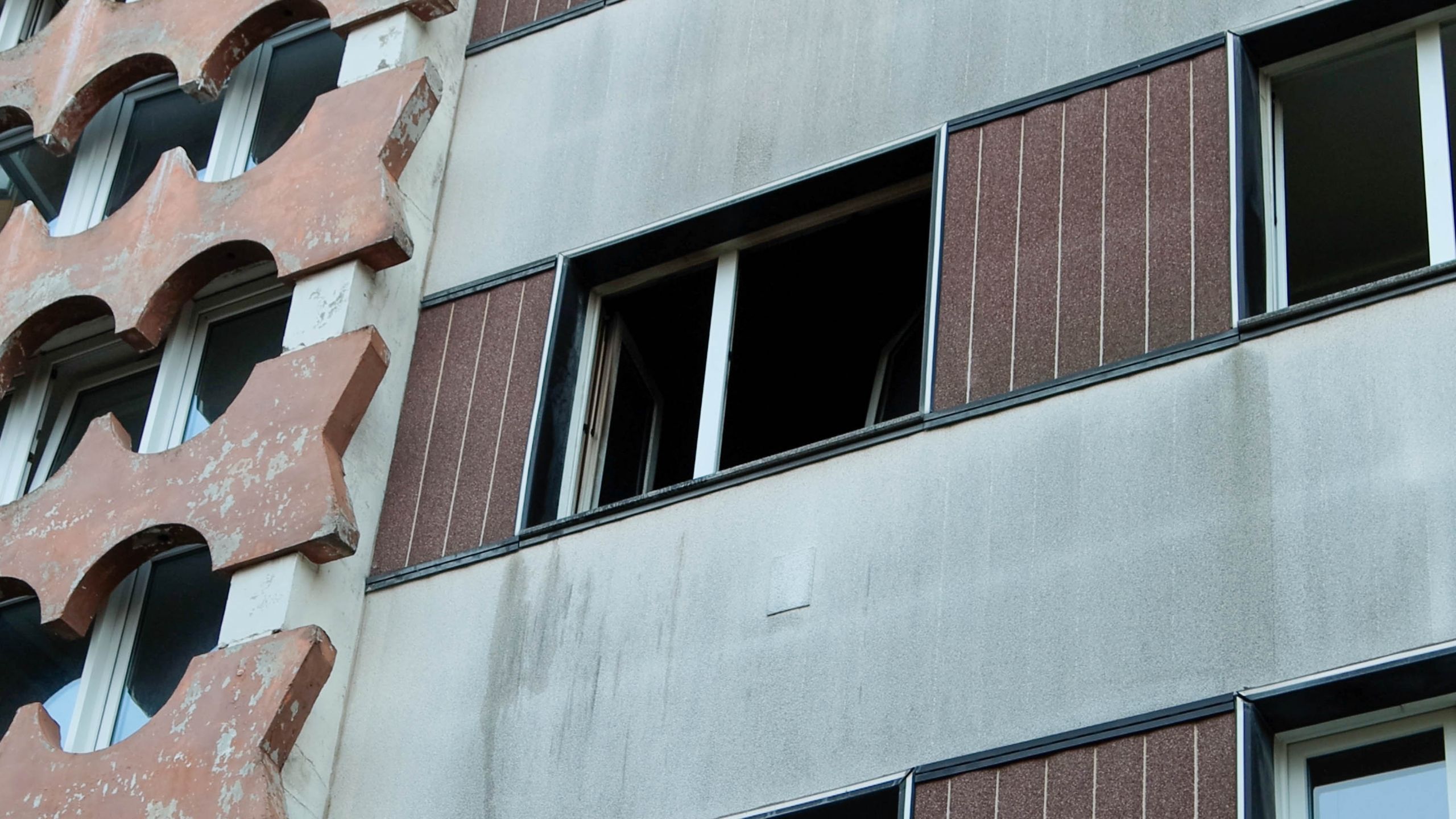 Foto nach dem Brand - offenes Fenster der ausgebrannten Wohnung in der Asylunterkunft