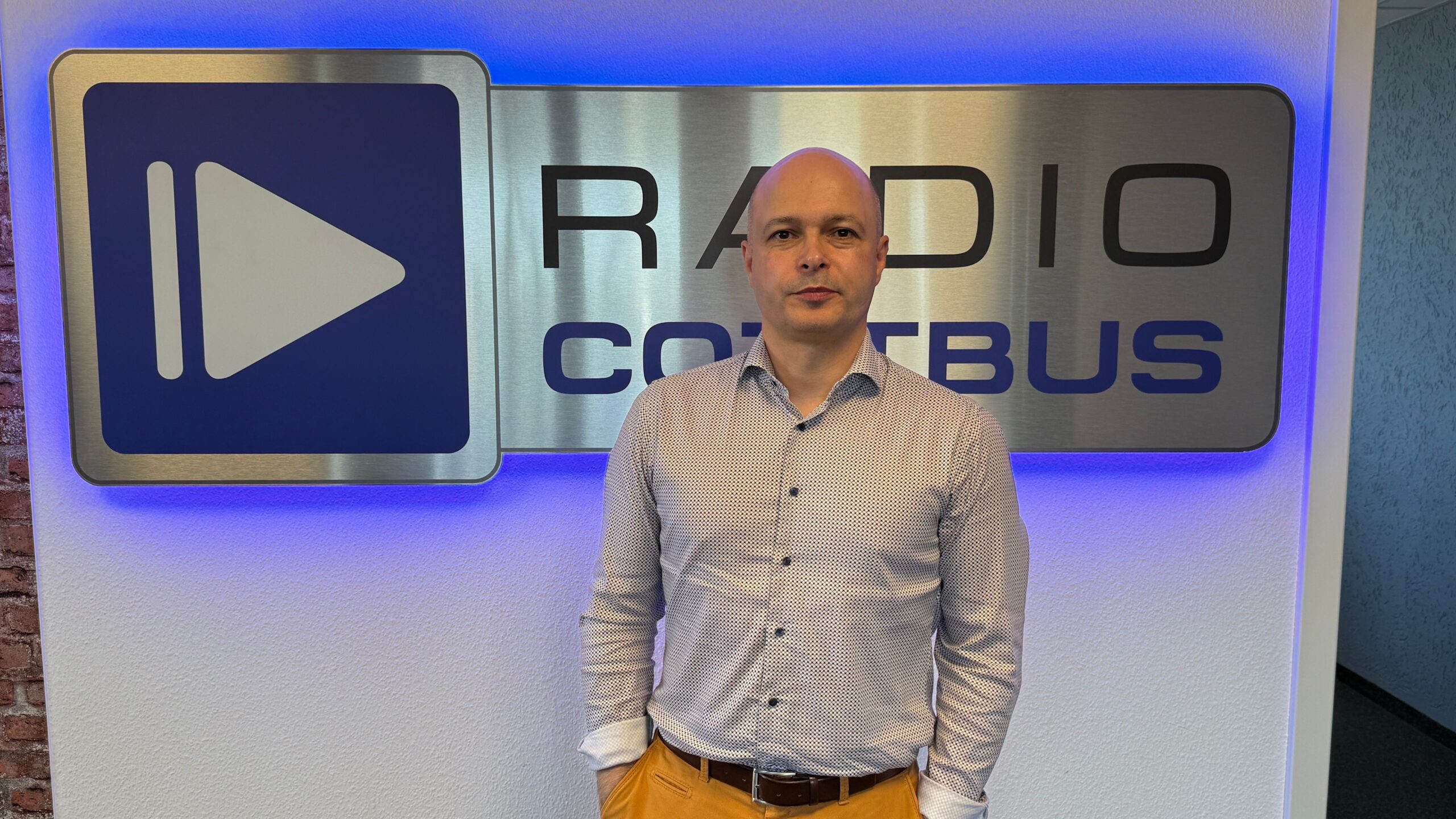 Guido Filipov von Euromovement vor dem Radio Cottbus Logo